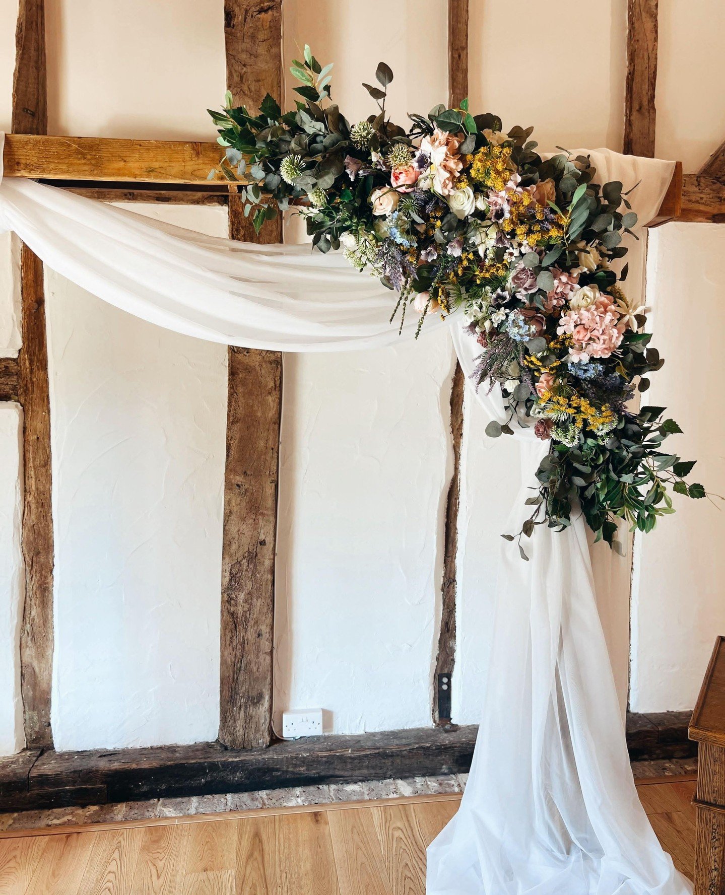 A natural wooden arch adorned with bespoke faux florals set the scene for a romantic &ldquo;I do,&rdquo; ⁠
⁠
With a ceremony aisle lined by accent ruscus and flickering candlelight.⁠
Sage green chair sashes added a soft, elegant touch. 🌿💚⁠
⁠
Every 