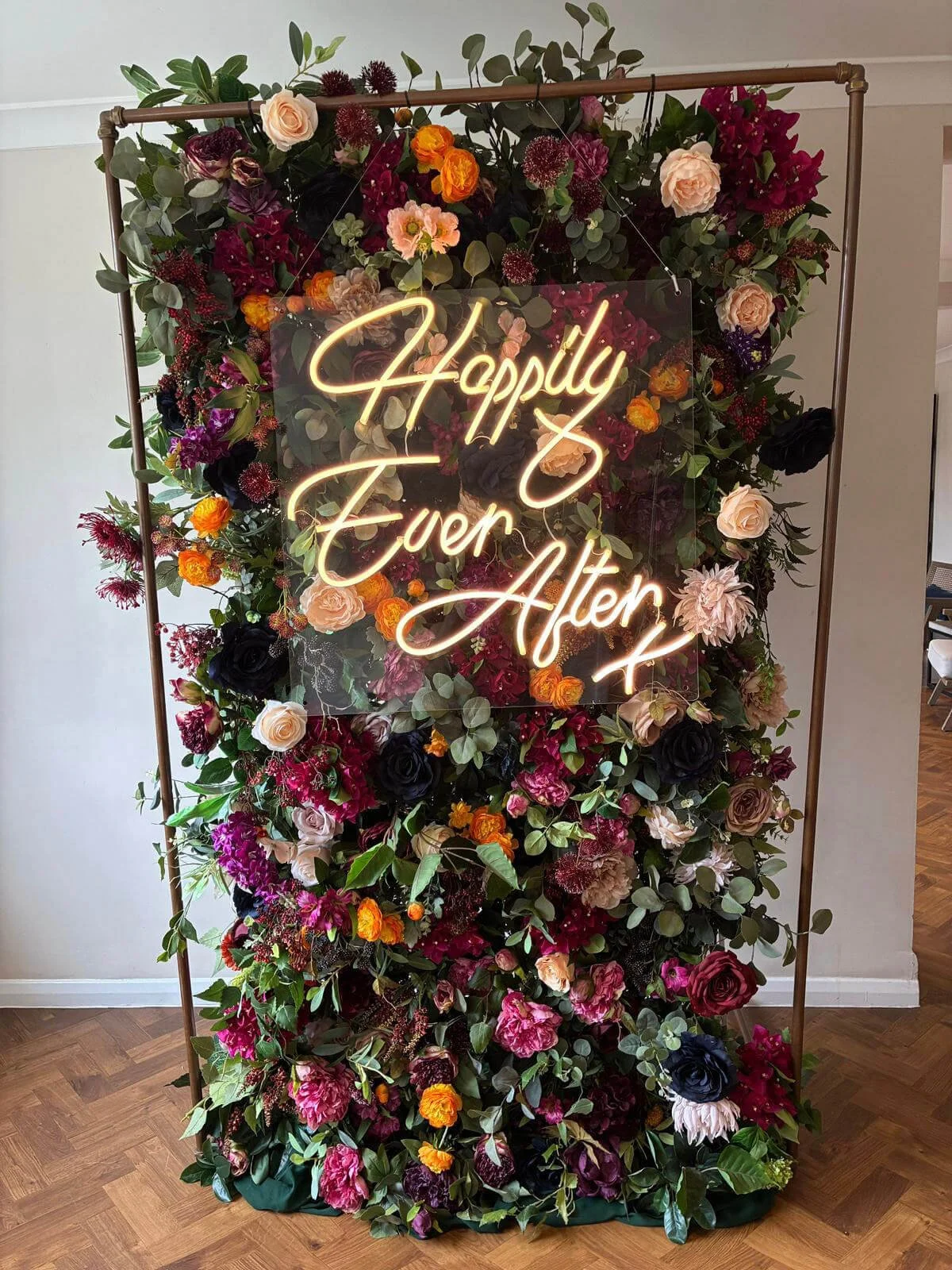 Floral Backdrop Panel with mixed colorful flowers and greenery on a copper frame, available to hire for your wedding or event.