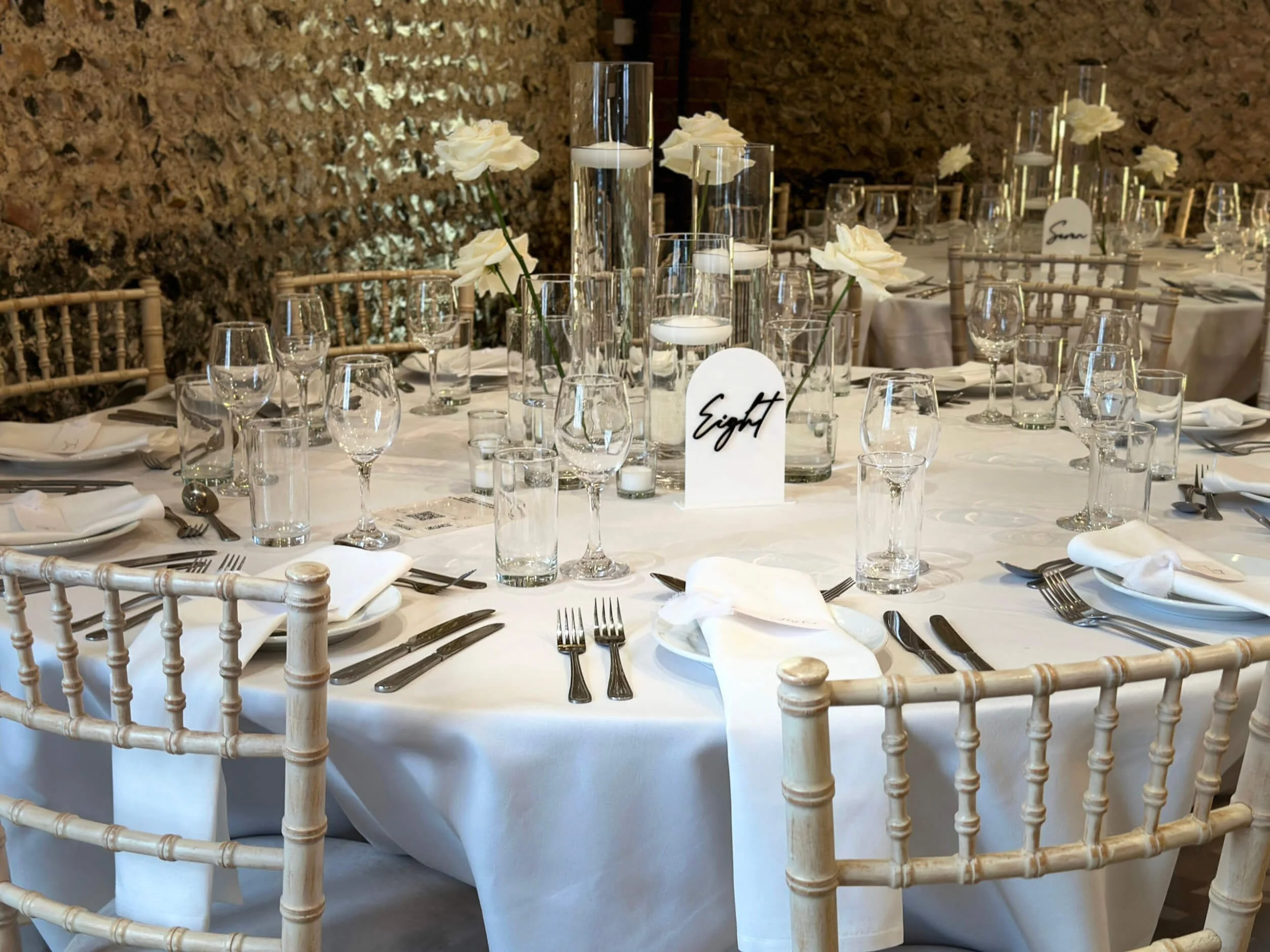 Bud Cylinder Vase - 20cm x 6cm clear glass vases with white roses and floating candles, available to hire for your wedding or event.