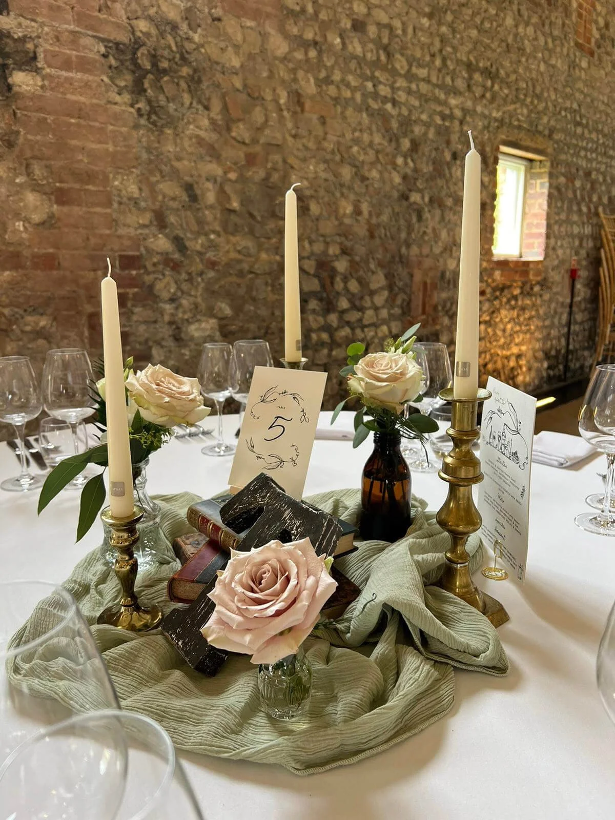 Gold mismatched vintage candlesticks with white taper candles and pale pink roses, available to hire for your wedding or event.