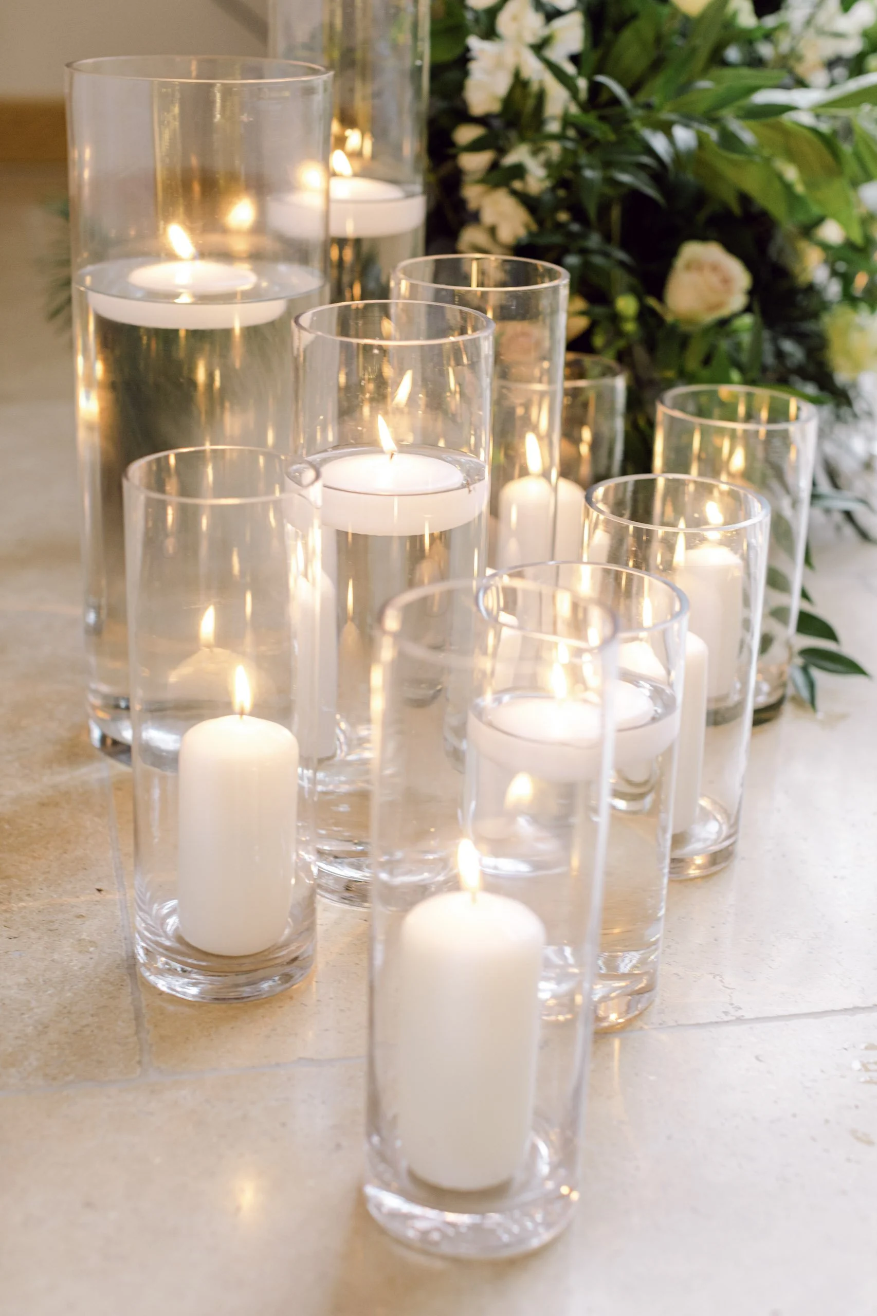 Cylinder Vase - 25cm - 12cm diameter with white floating and pillar candles, available to hire for your wedding or event.
