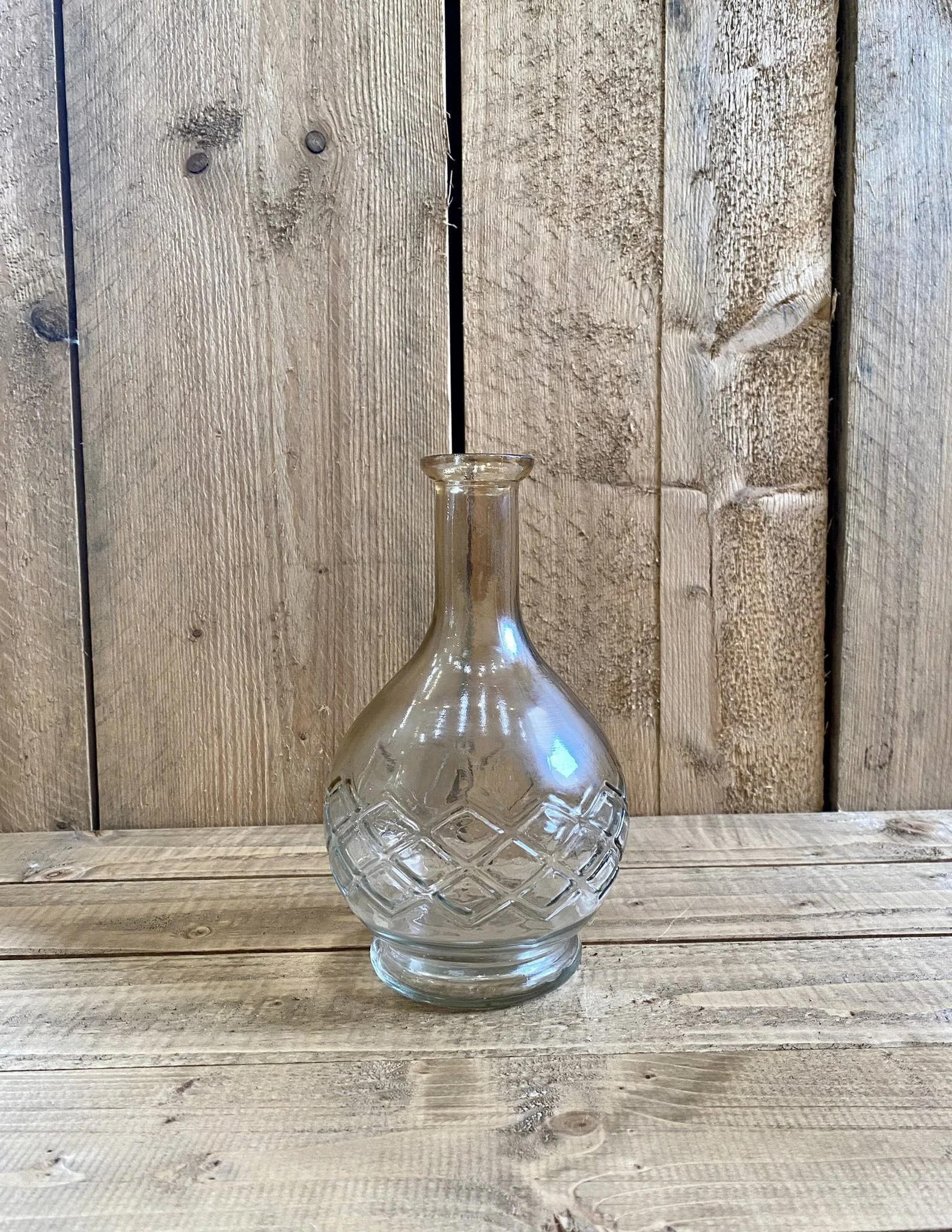 Elia Glass Bud Vase clear with diamond pattern on round base, available to hire for your wedding or event, displayed on rustic wooden surface.