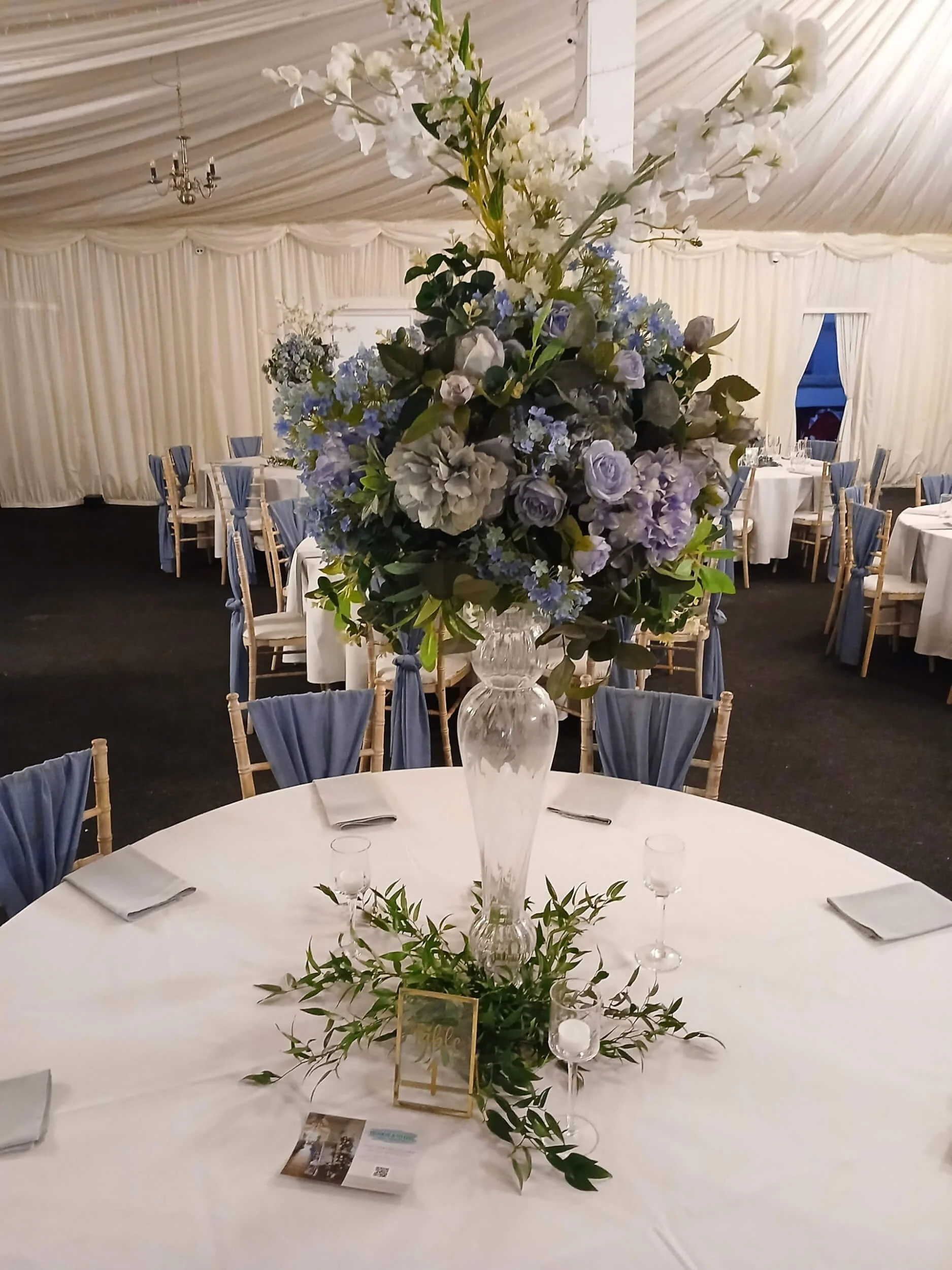 Ripple Centrepiece Glass Vase with white and pale blue floral arrangement, available to hire for your wedding or event.