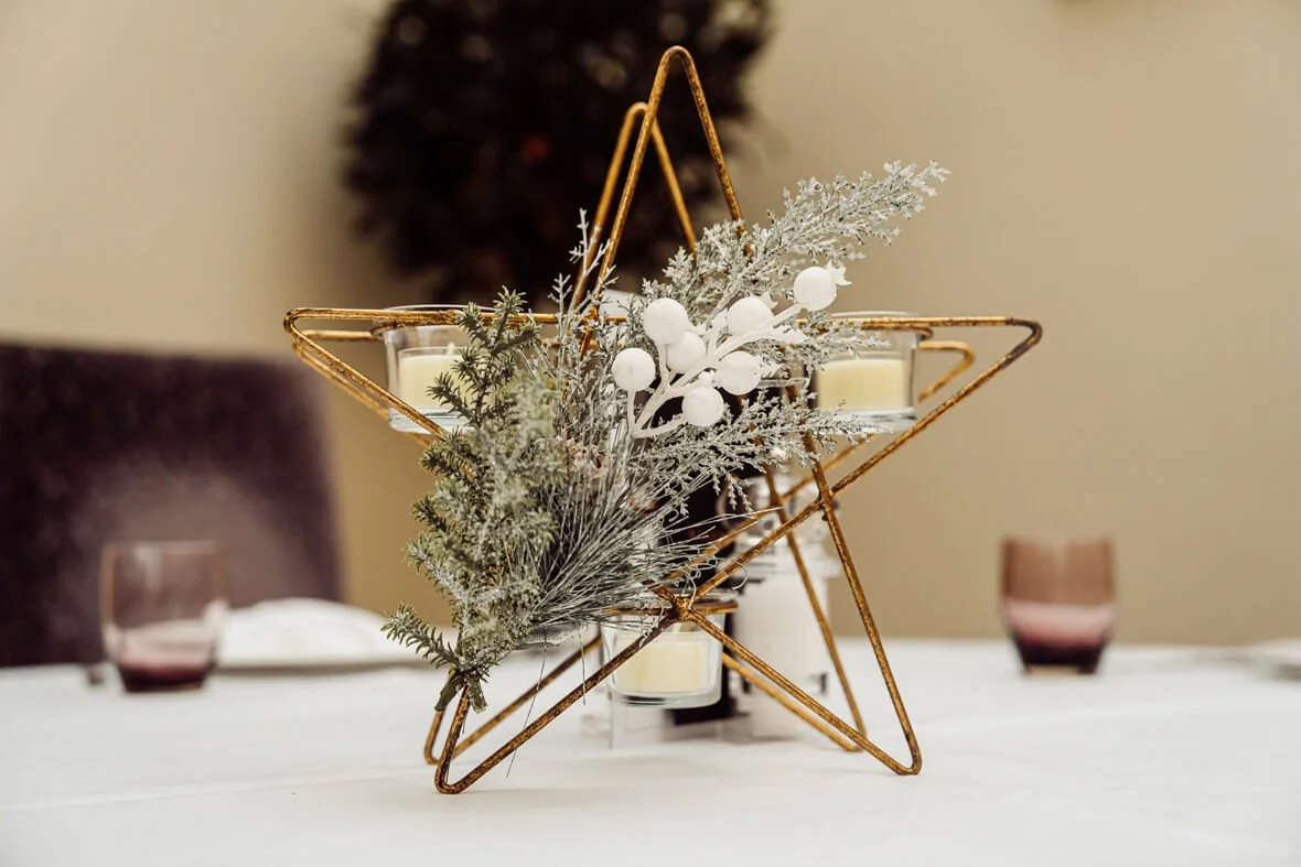 Triple Tealight Star Holder - 30 x 8.5x28cm gold star-shaped holder with three tealights and frosted foliage, available to hire for your wedding or event.