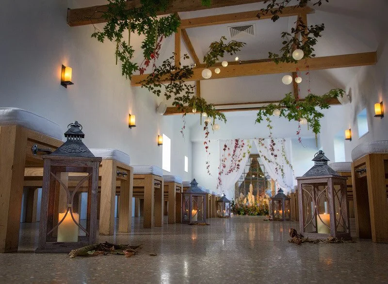 Wooden Rustic Lanterns with candles inside placed along an aisle in a decorated indoor venue, available to hire for your wedding or event.