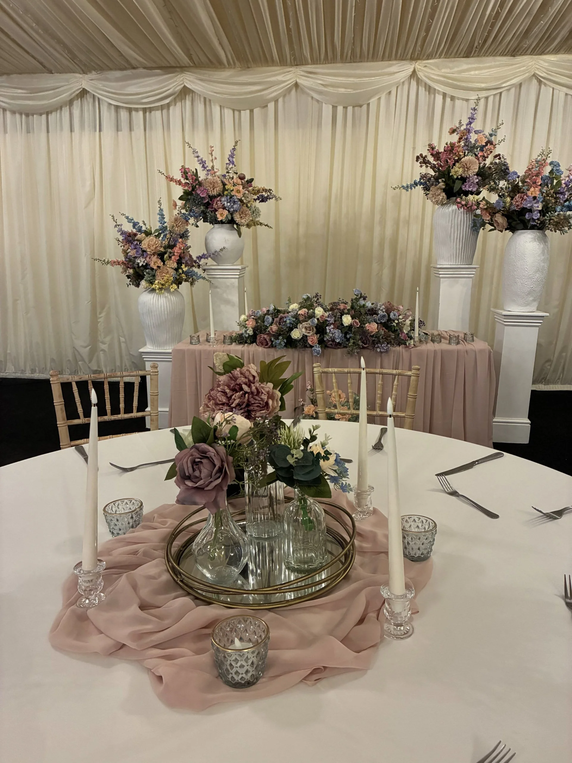 Mirrored Tray Gold on a white table with pink fabric and glass vases with flowers, available to hire for your wedding or event.