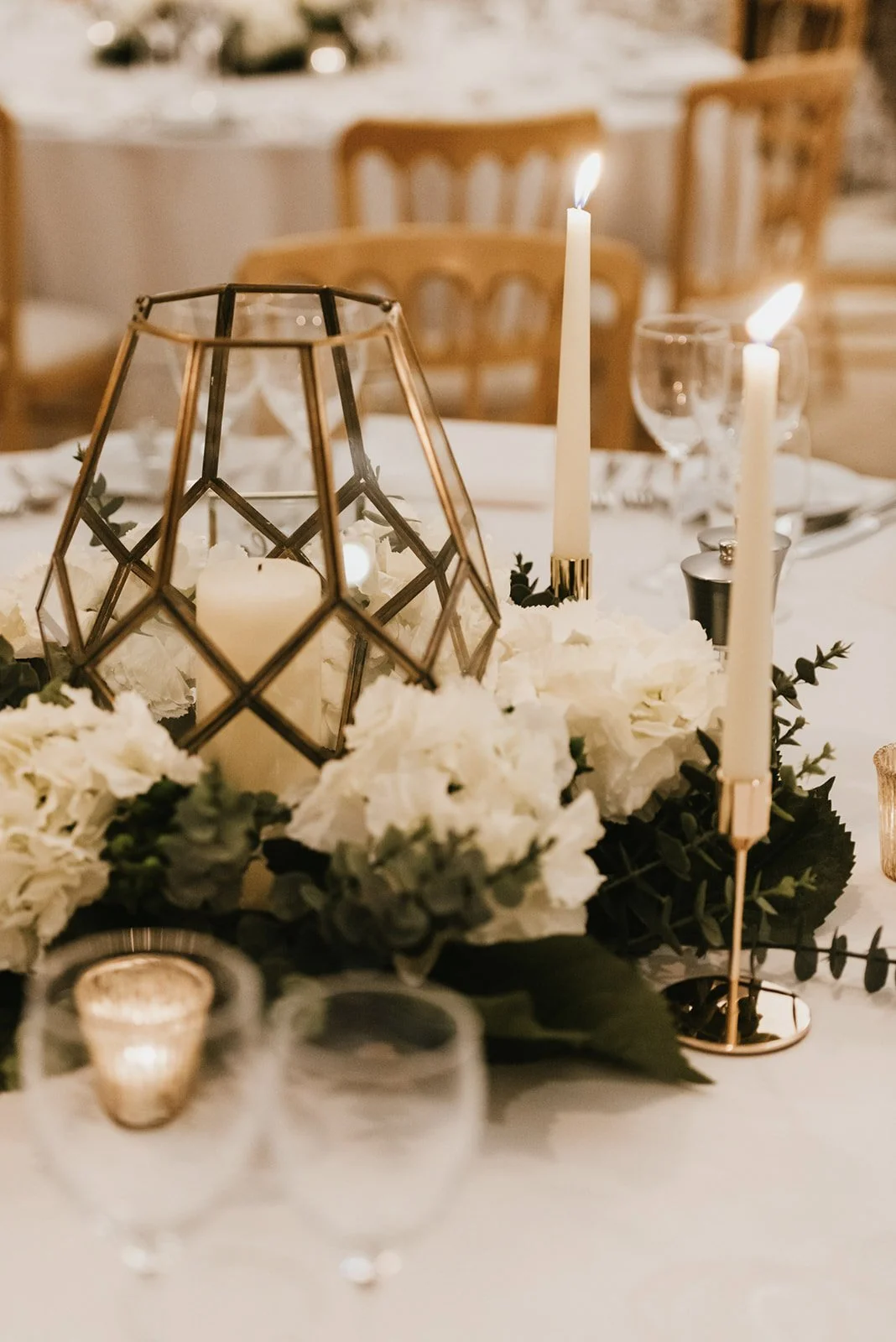 Hydrangea Faux Flower large Wreath with white blooms and greenery around a geometric glass candle holder, available to hire for your wedding or event.