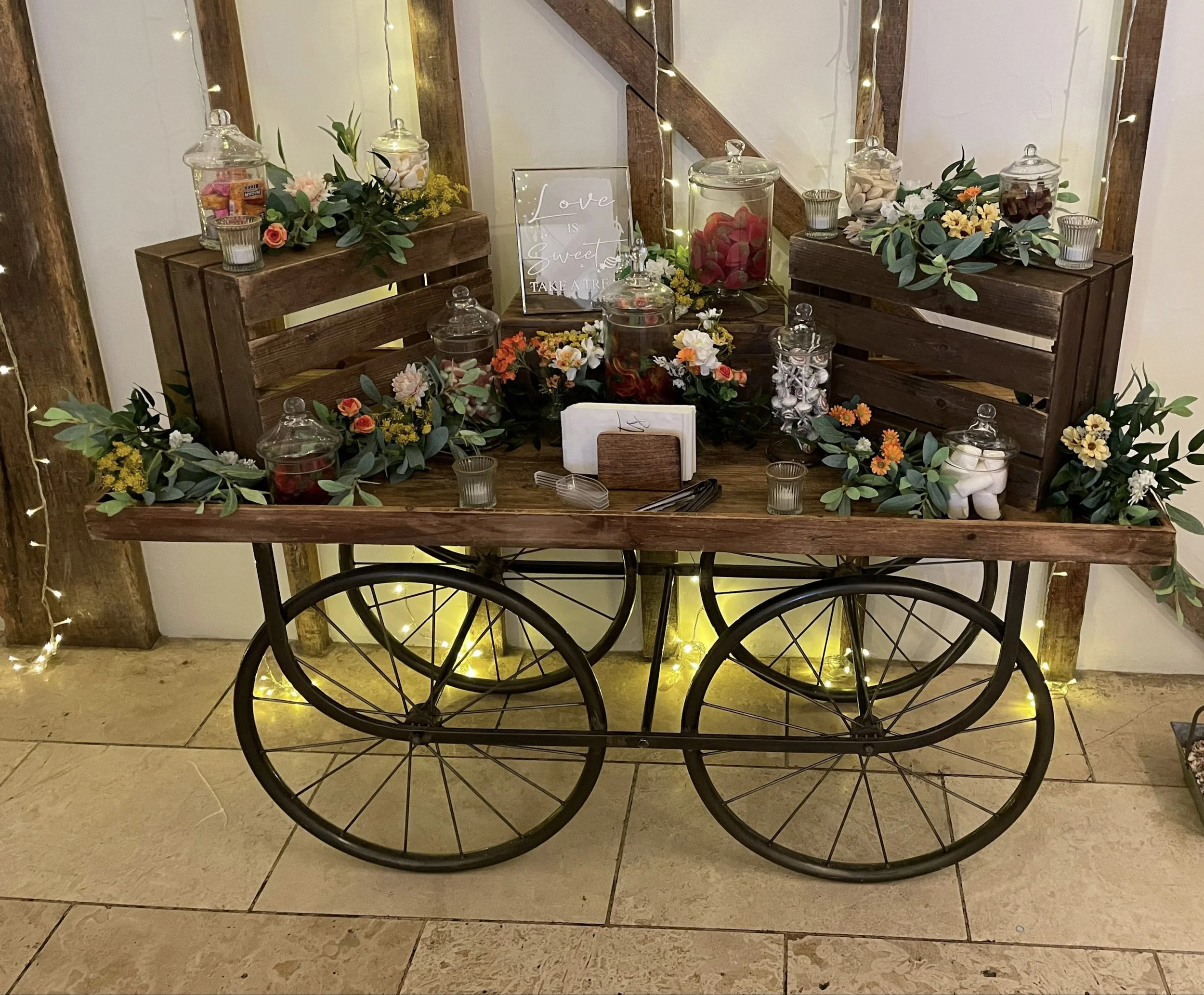 Rustic Wagon with glass jars of sweets and floral decorations, available to hire for your wedding or event.