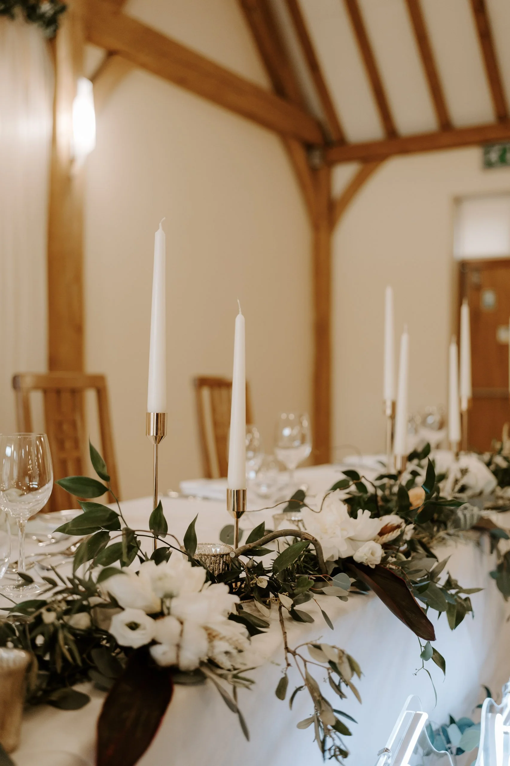Tapered candlestick - Gold - Extra Small - 14cm in gold with white candles, available to hire for your wedding or event, displayed on a decorated table.