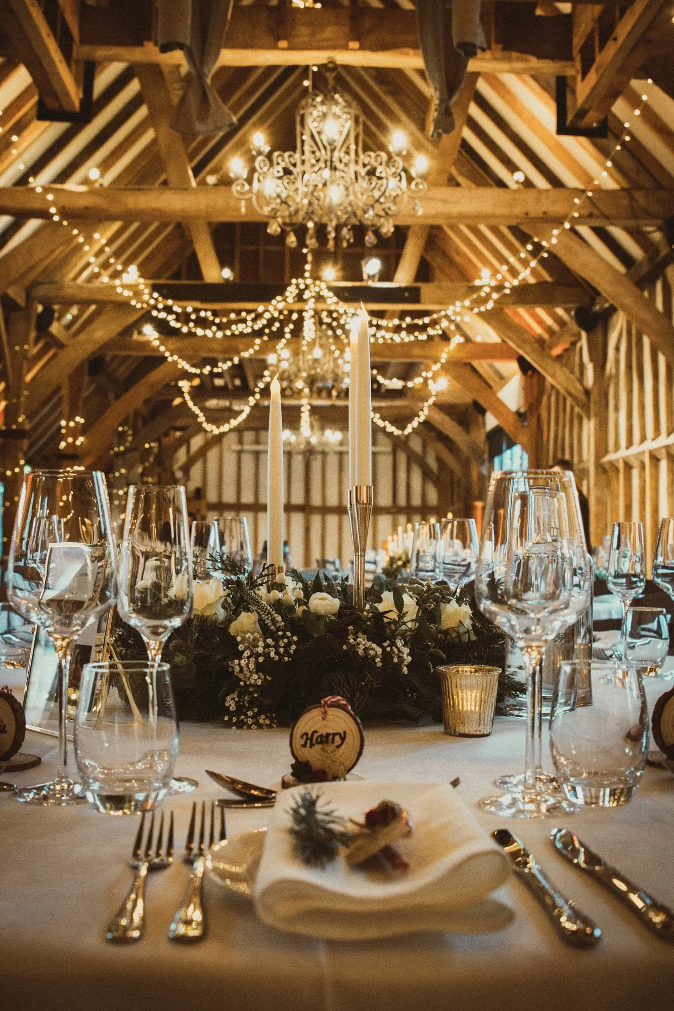 Tapered candlestick - Gold - Small 17cm holding a white candle on a decorated table, available to hire for your wedding or event in a rustic barn setting.
