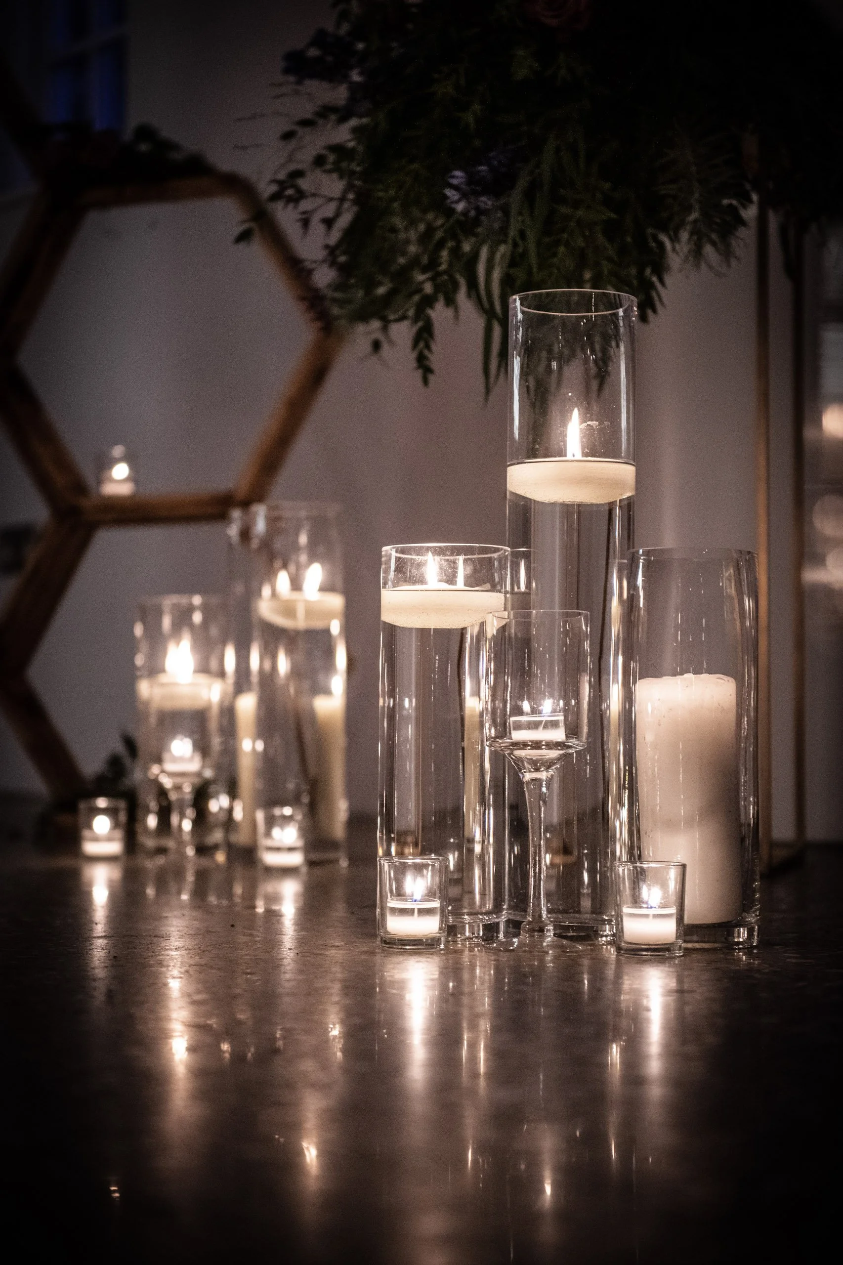 Cylinder Vase - 90cm x 15cm diameter with floating candles inside, available to hire for your wedding or event, creating elegant ambient lighting.
