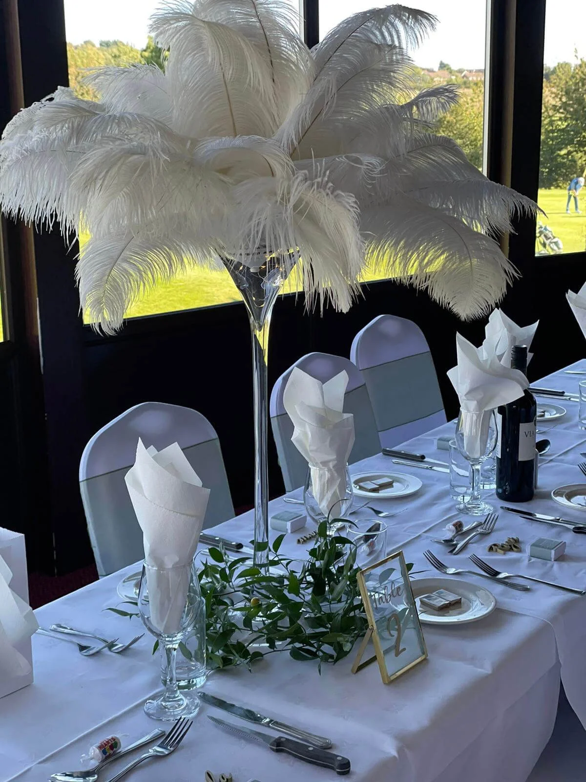 Martini Vase - 60cm tall clear vase with large white feathers centerpiece, available to hire for your wedding or event.