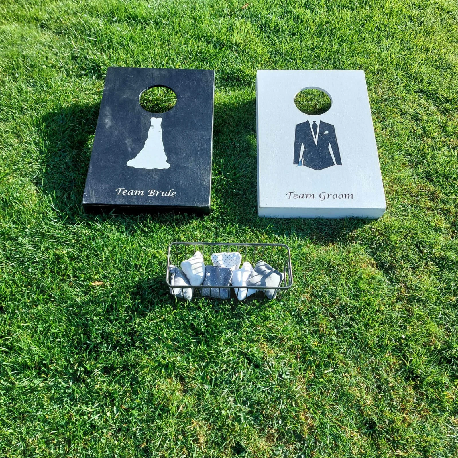 Cornhole Toss - Mr & Mrs with black and white boards featuring bridal dress and suit designs, available to hire for your wedding or event.