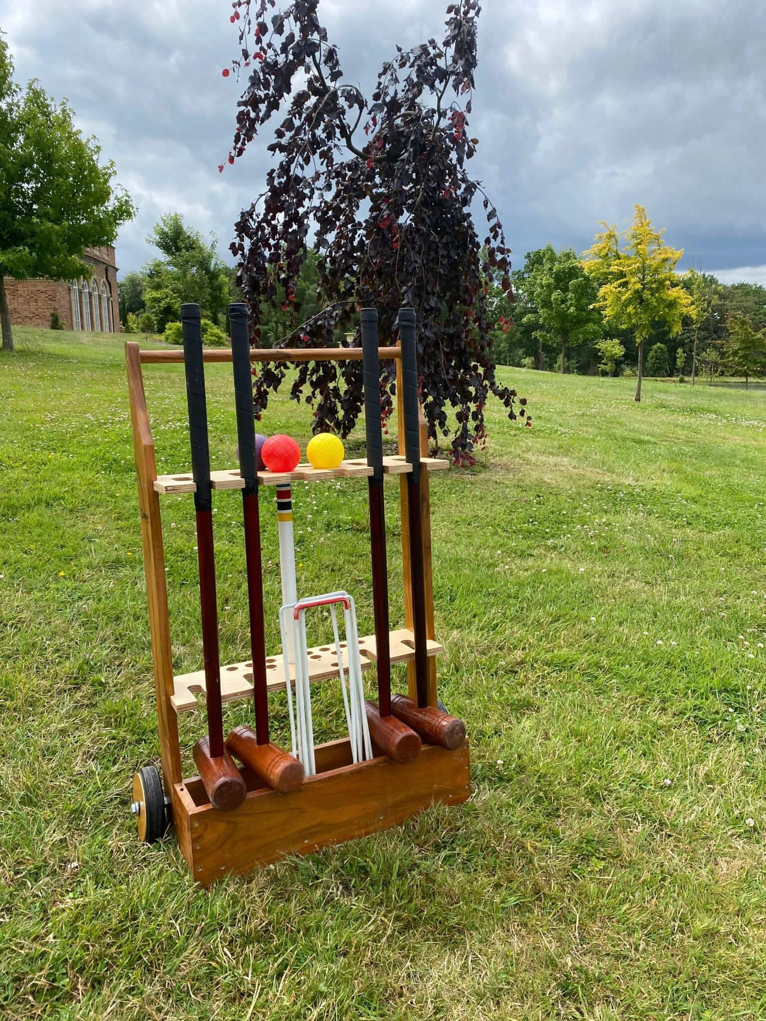 Croquet set with mallets, balls, and wickets on grass, available to hire for your wedding or event.