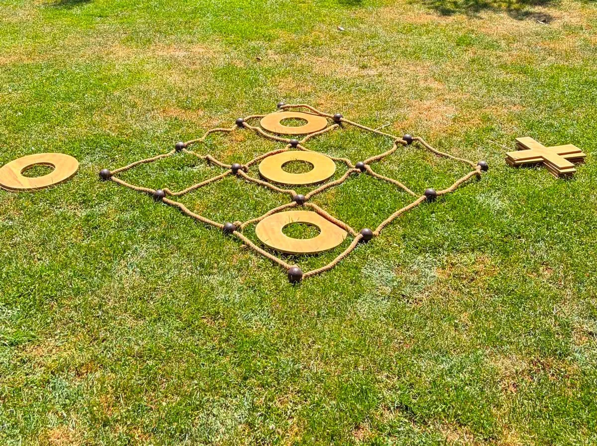 Giant Noughts and Crosses game with large wooden O and X pieces and rope grid available to hire for your wedding or event.