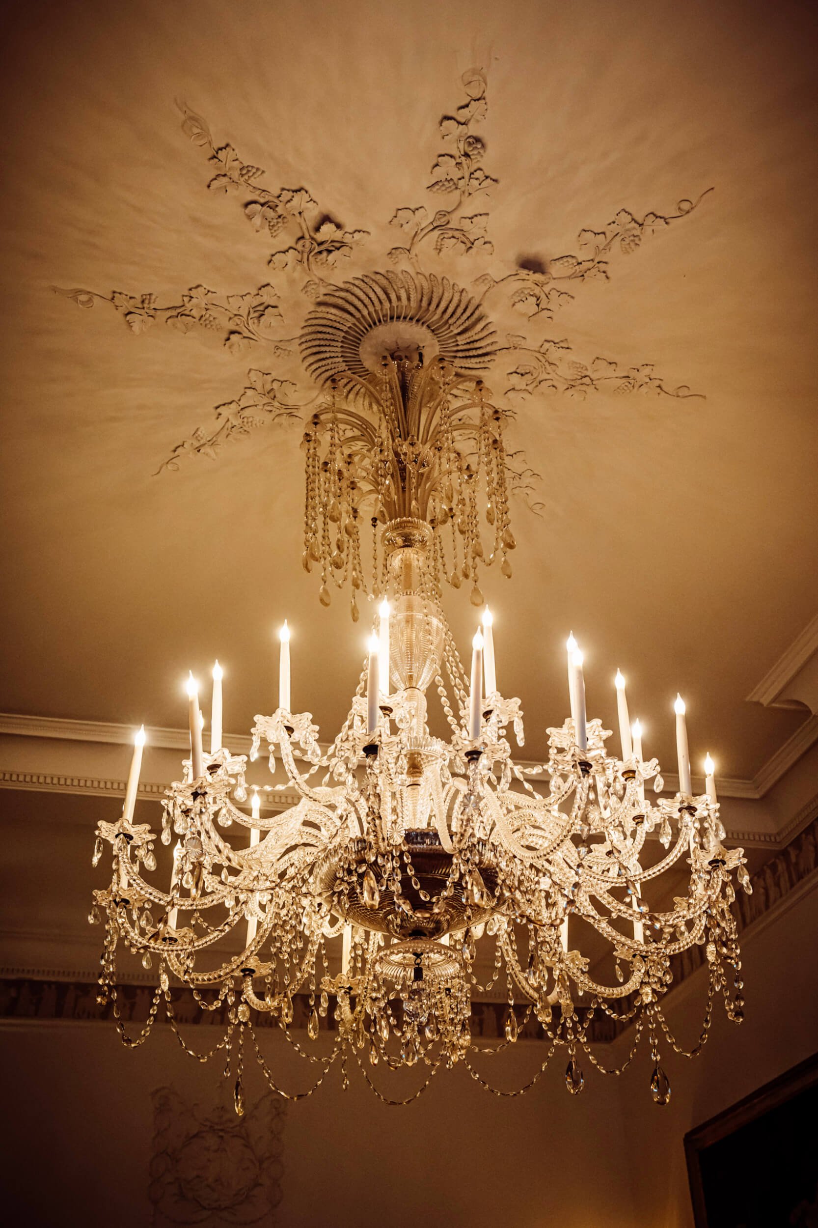 Classic Chandelier with multiple candle-style lights and crystal drops, available to hire for your wedding or event.