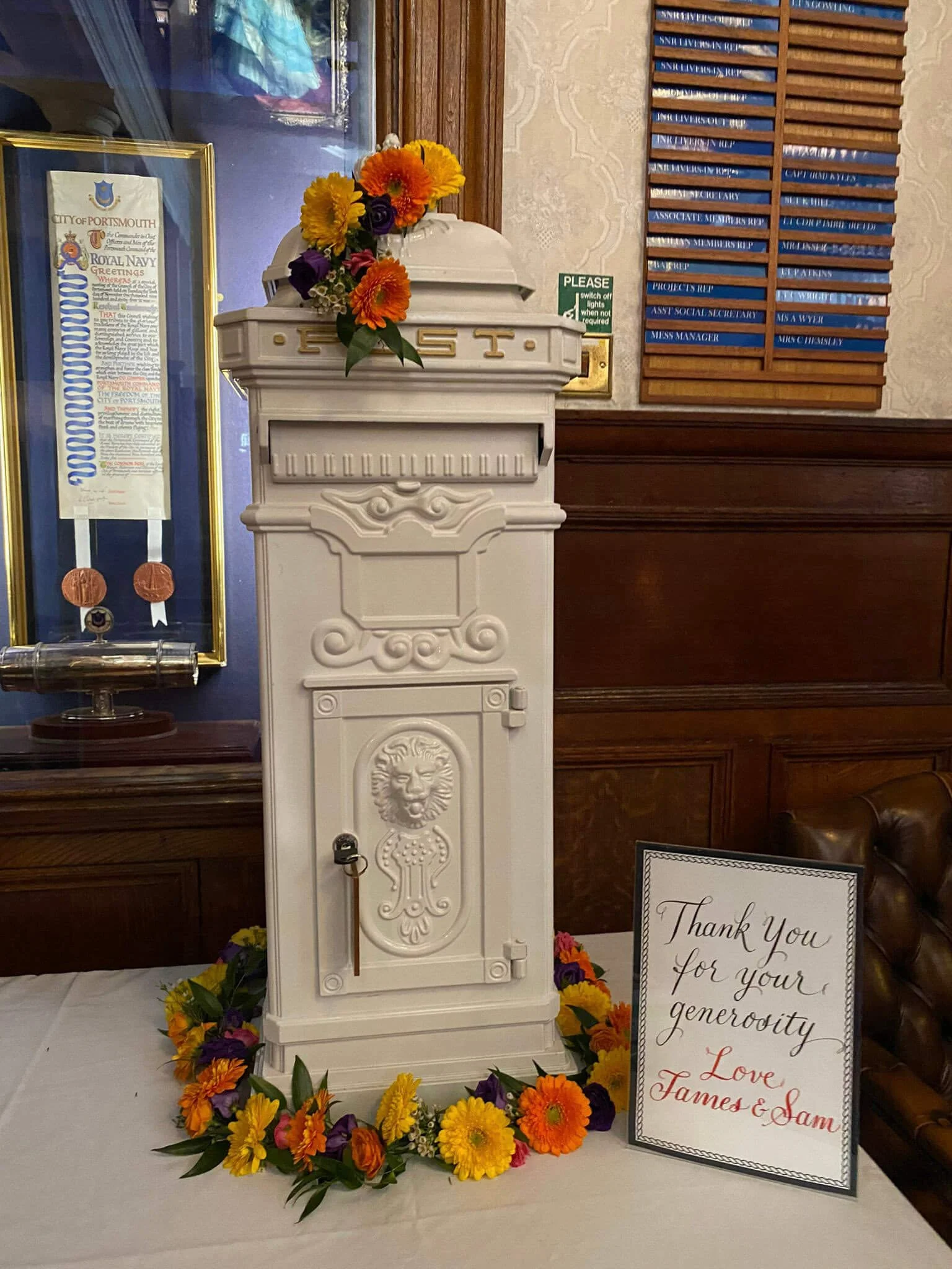 White Freestanding Post Box decorated with colorful flowers, available to hire for your wedding or event.