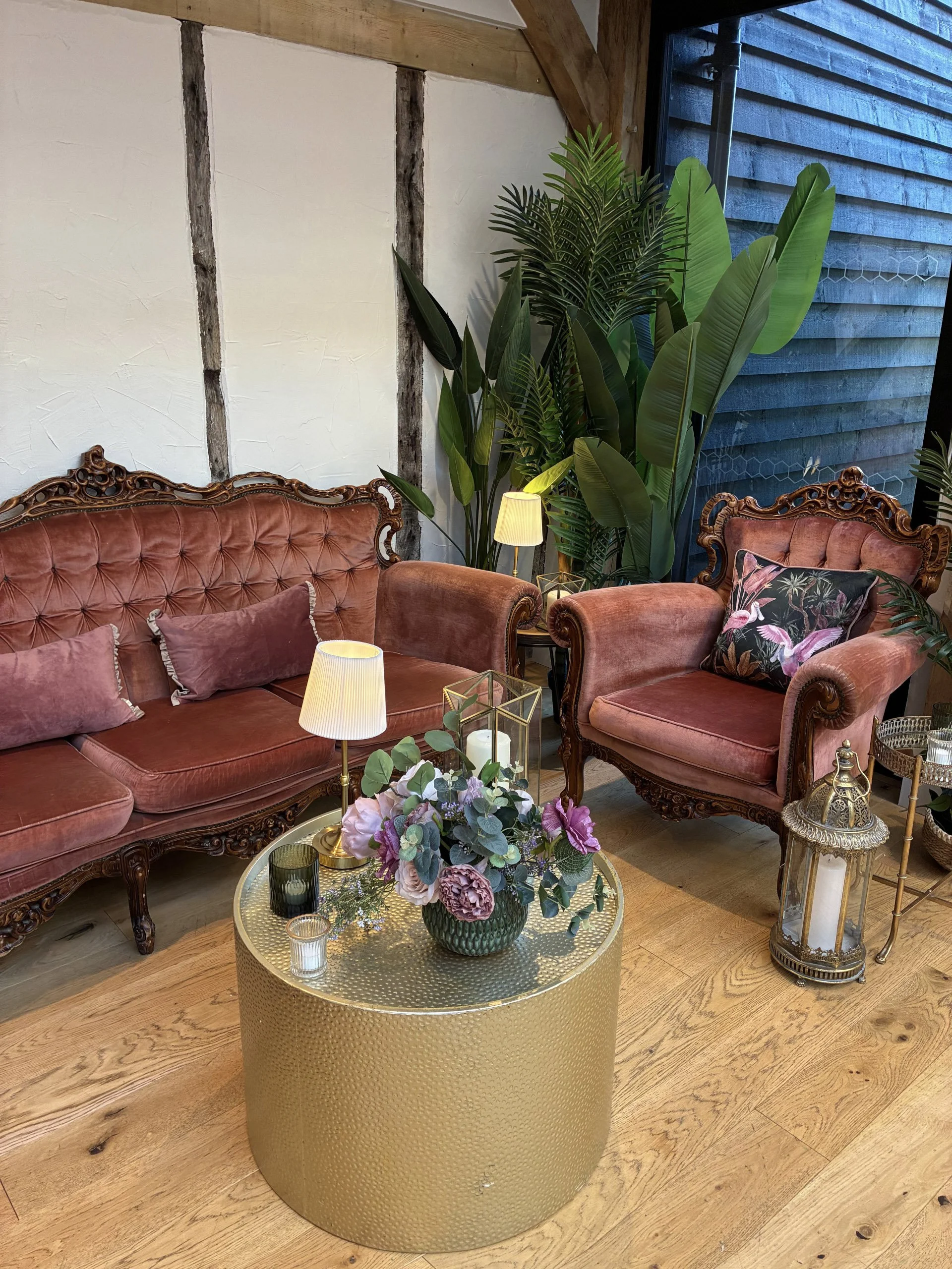 Gold Hammered Coffee Table with floral arrangement and candles, available to hire for your wedding or event in a vintage styled seating area.