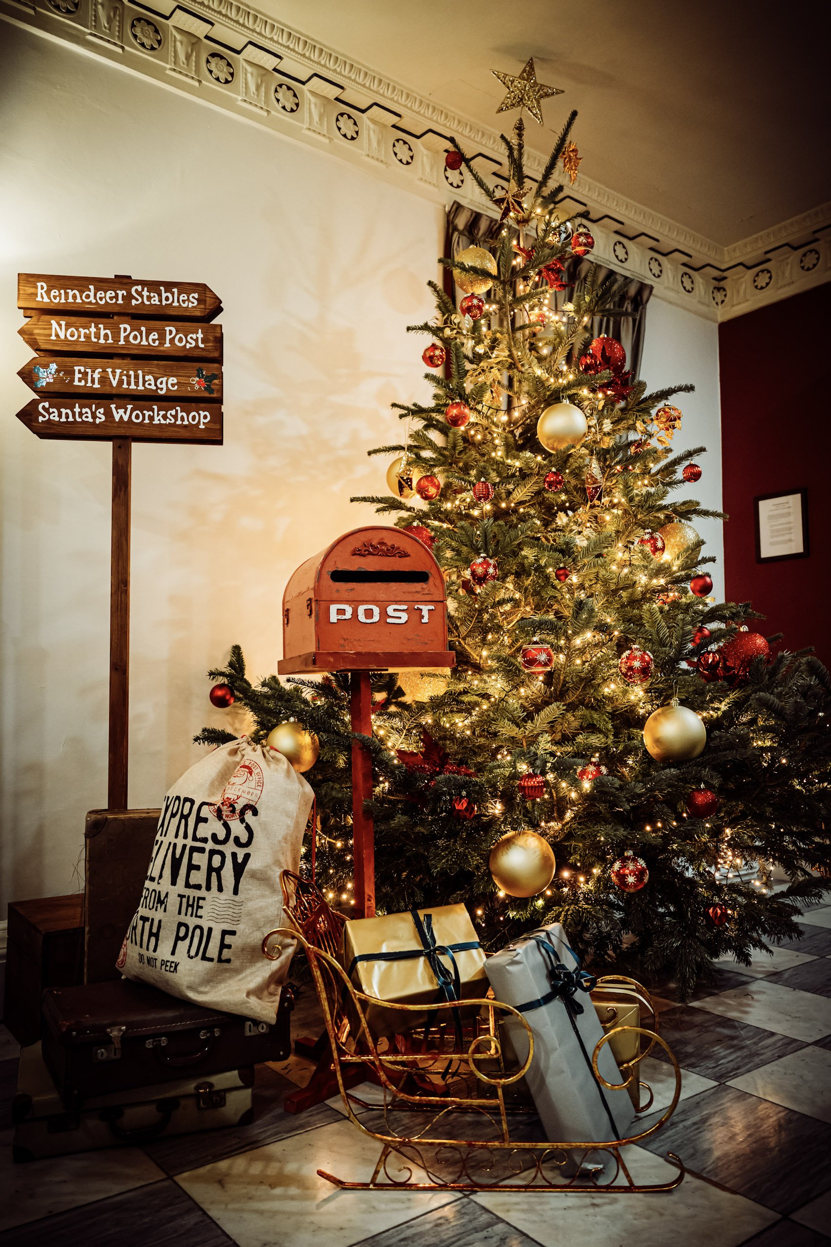 Rustic Red Post Box in a festive setting with Christmas tree and decorations, available to hire for your wedding or event.