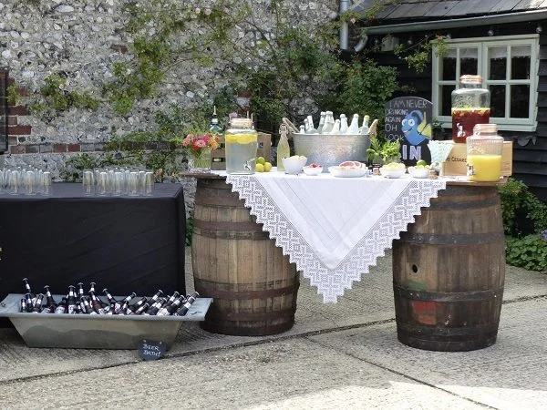 Barrel Bar with wooden barrels, drinks dispensers, and ice bucket, available to hire for your wedding or event.
