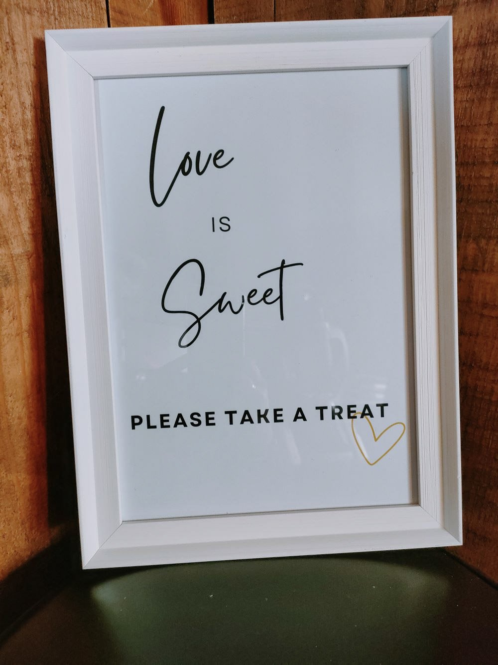 Love is Sweet Sign - White Framed with black text and gold heart, available to hire for your wedding or event.