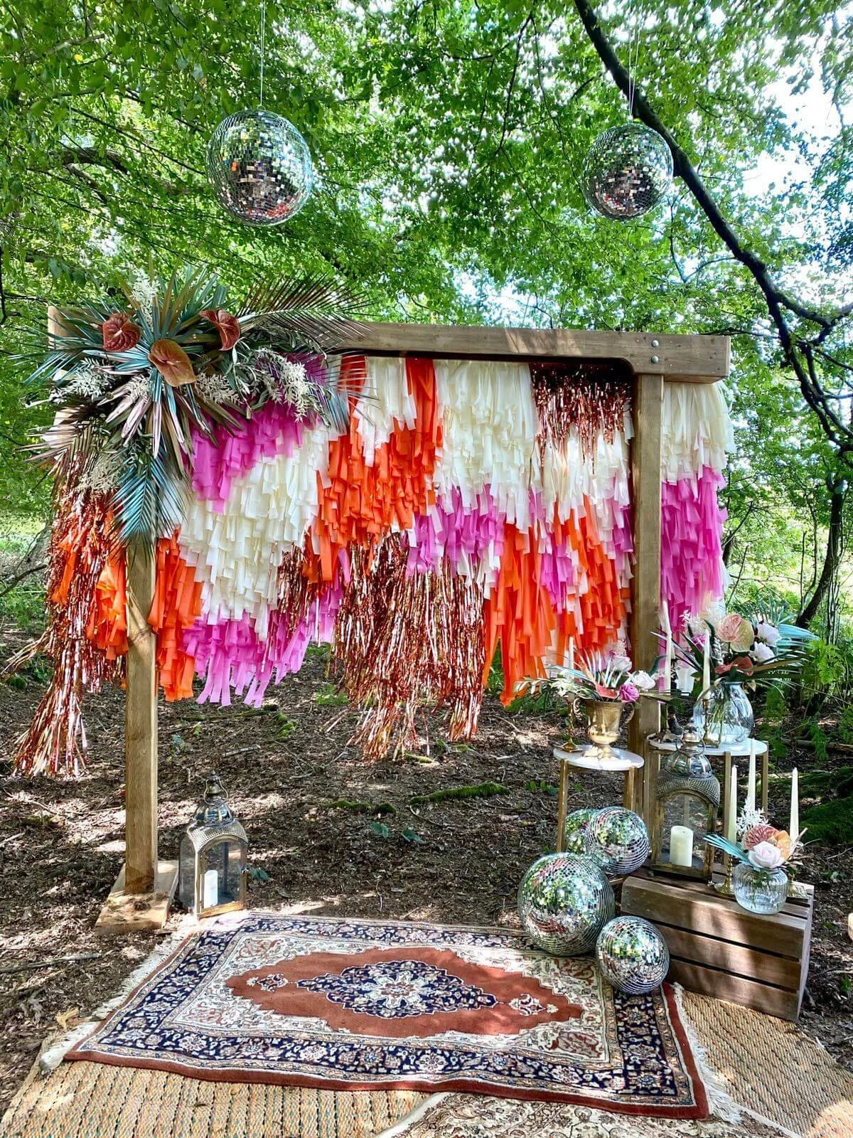 Tassel/Fringe Backdrop - Bespoke Colours with pink, orange, cream, and copper tassels on a wooden frame, available to hire for your wedding or event.