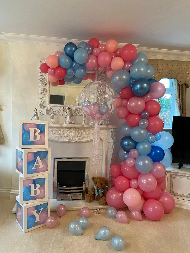 Balloon Demi Arch in pink, blue, and purple shades available to hire for your wedding or event, displayed indoors with a clear balloon and BABY blocks.