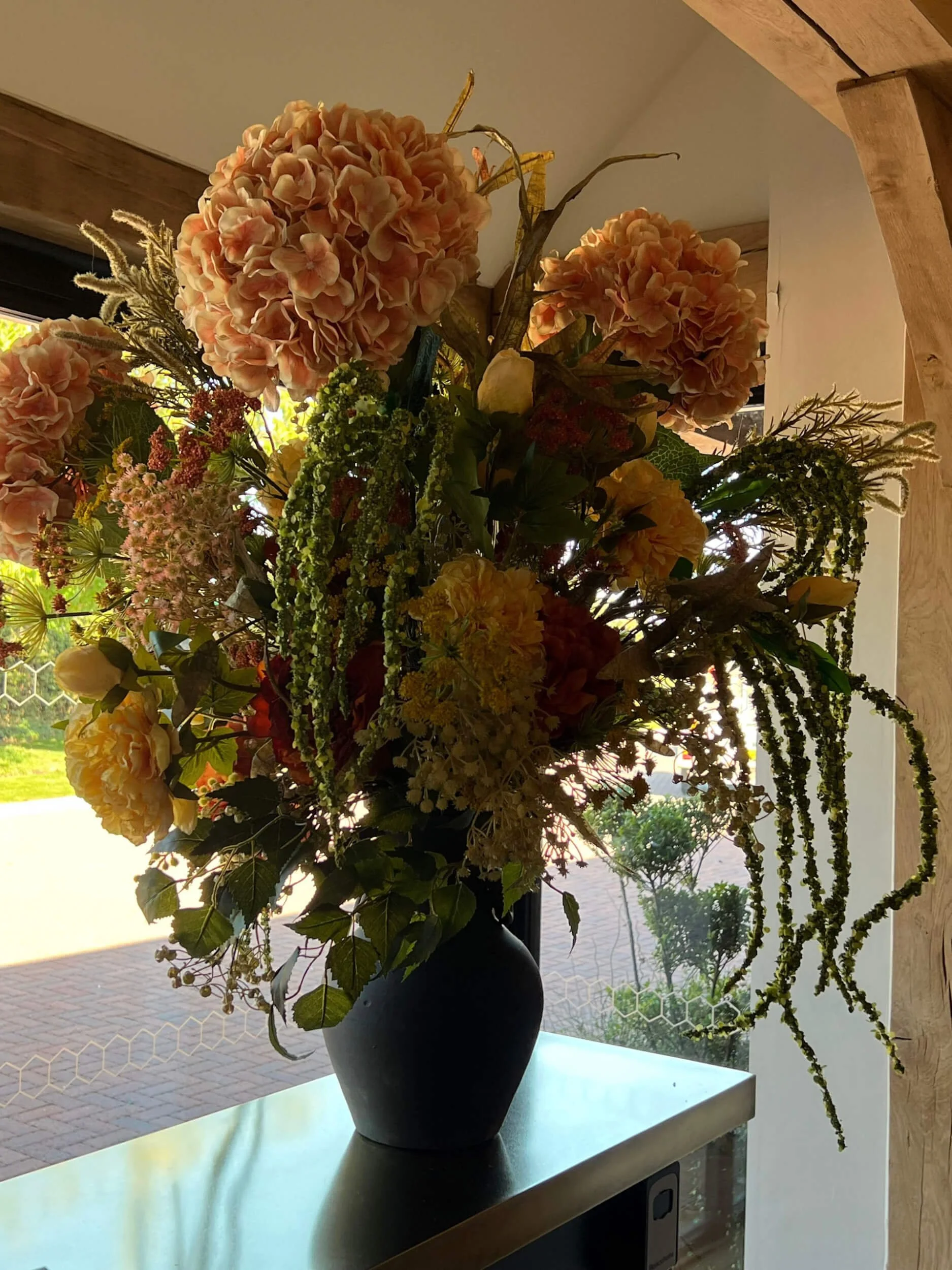 Ceramic Charcoal Vase - 46cm H x 34.5cm W with peach and yellow floral arrangement, available to hire for your wedding or event.
