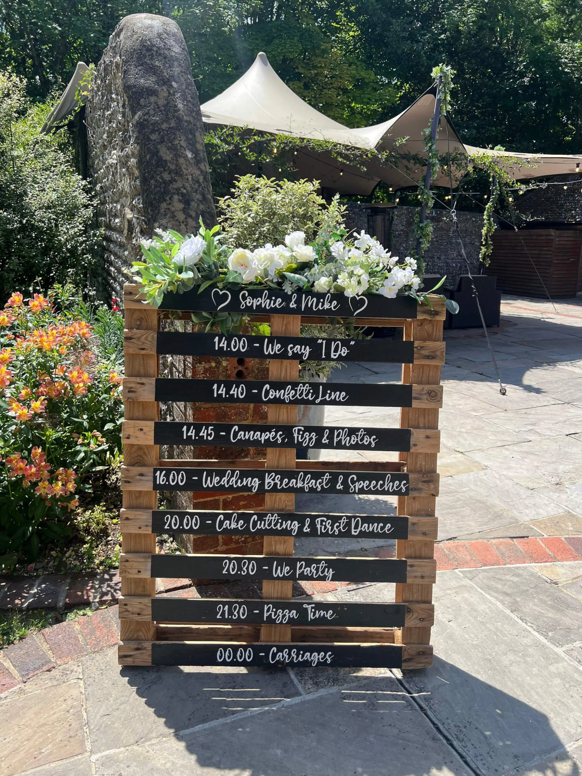 Pallet Run of the day - includes custom decals wooden pallet with white flowers and wedding schedule decals, available to hire for your wedding or event.