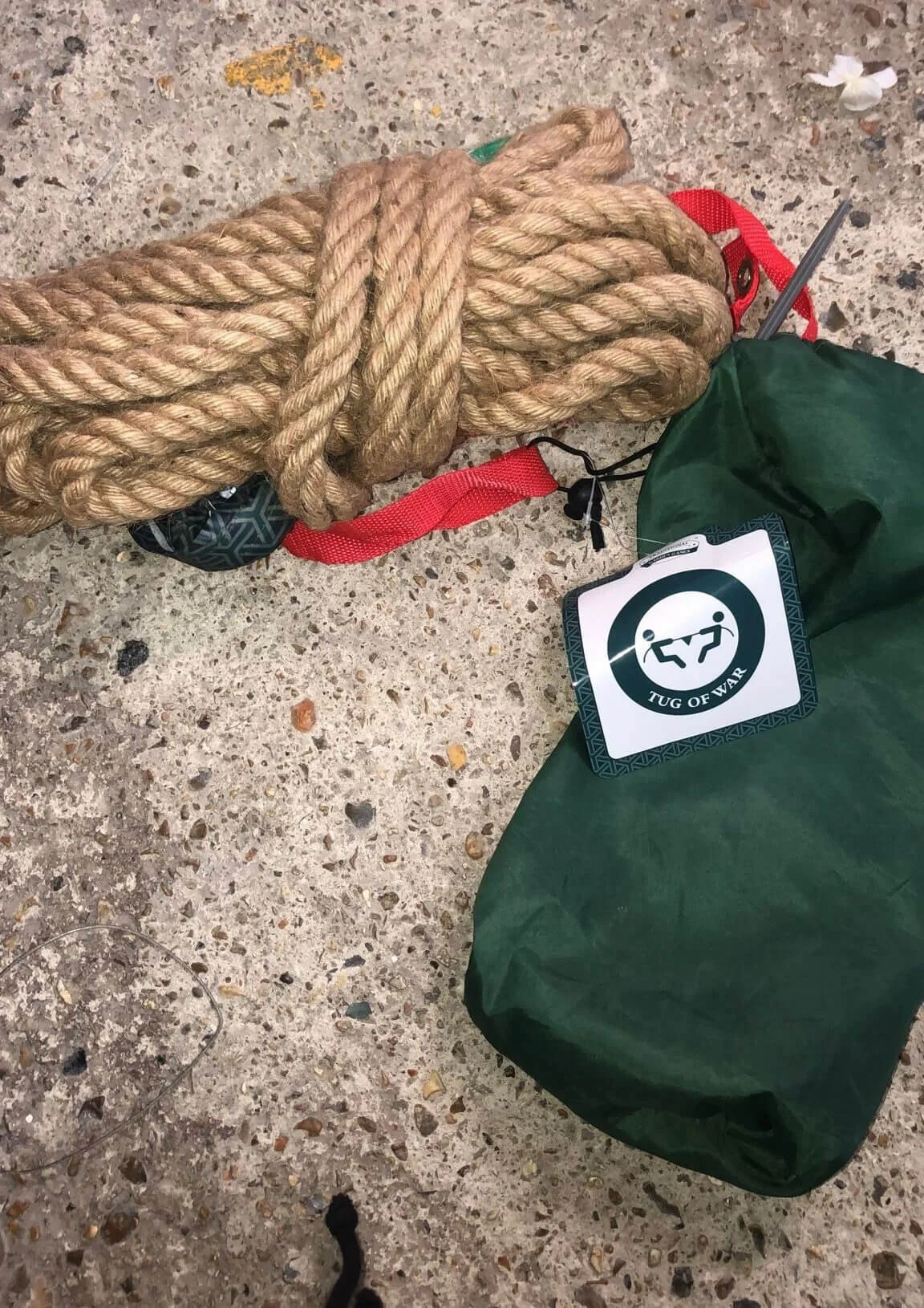 Tug Of War coiled rope with red strap and green bag, available to hire for your wedding or event.