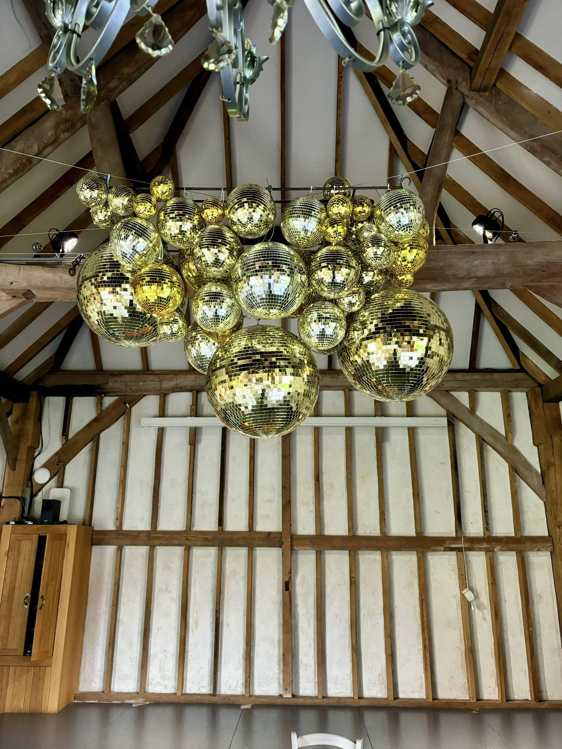 Mirror Ball/Disco Ball - Gold - 20 inch cluster hanging from ceiling in rustic venue, available to hire for your wedding or event.