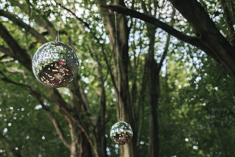 Mirror Ball/Disco Ball - Silver - 20 inch hanging outdoors among trees, available to hire for your wedding or event.