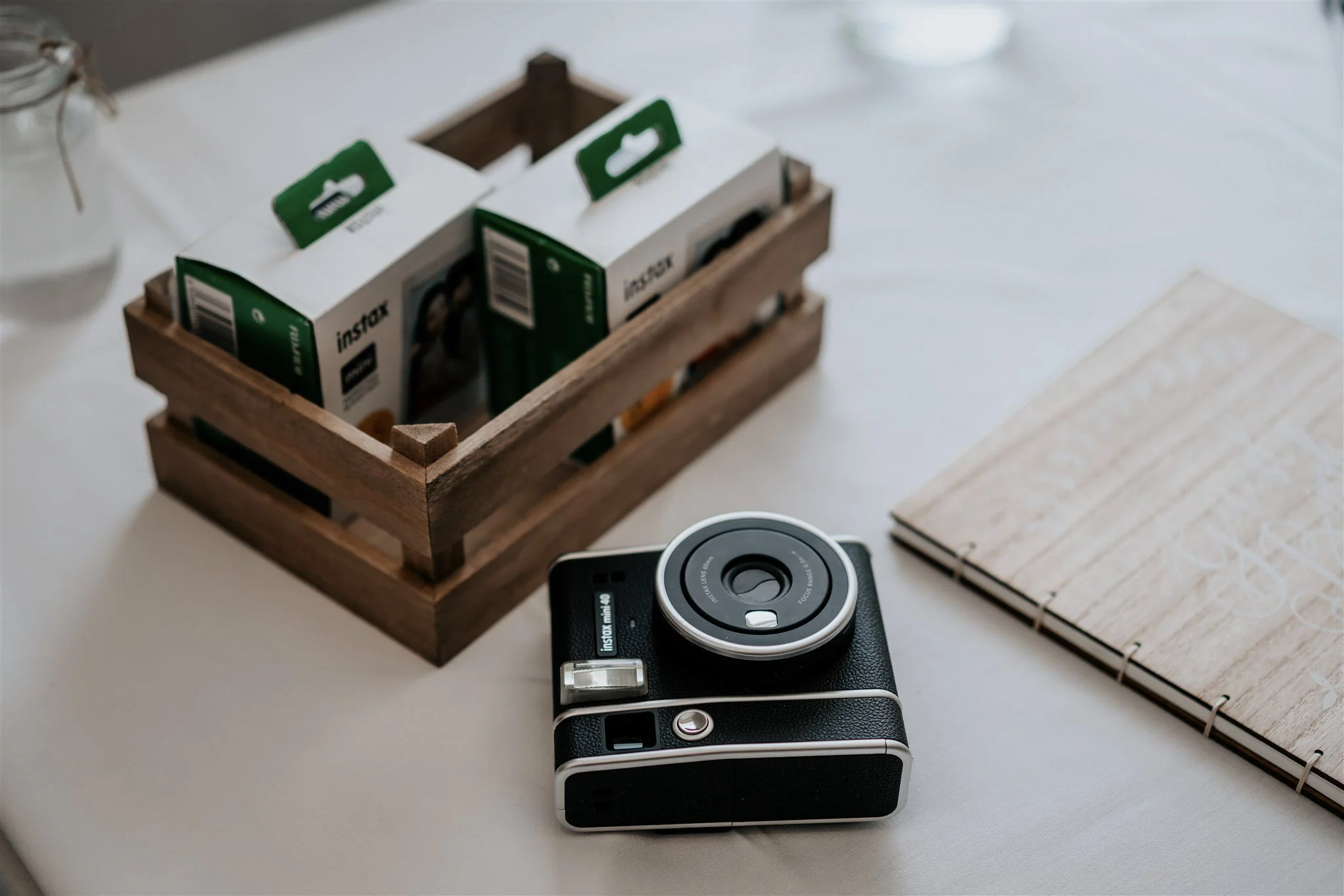 Vintage Look Polaroid Camera with Instax film boxes in a wooden crate, available to hire for your wedding or event.