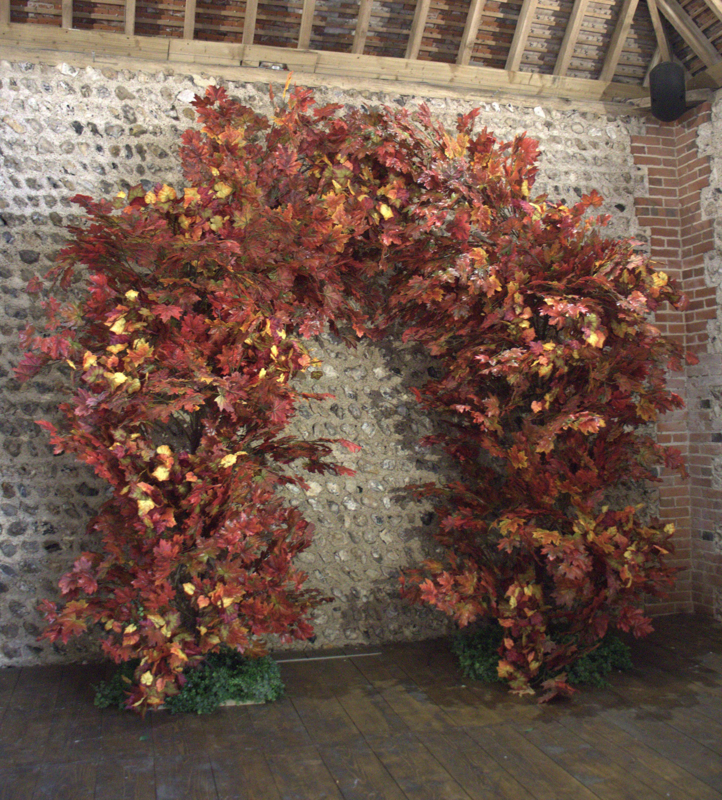 Branch Arch - Autumn 310cm x 270cm with vibrant autumn leaves in red, orange, and yellow, available to hire for your wedding or event.