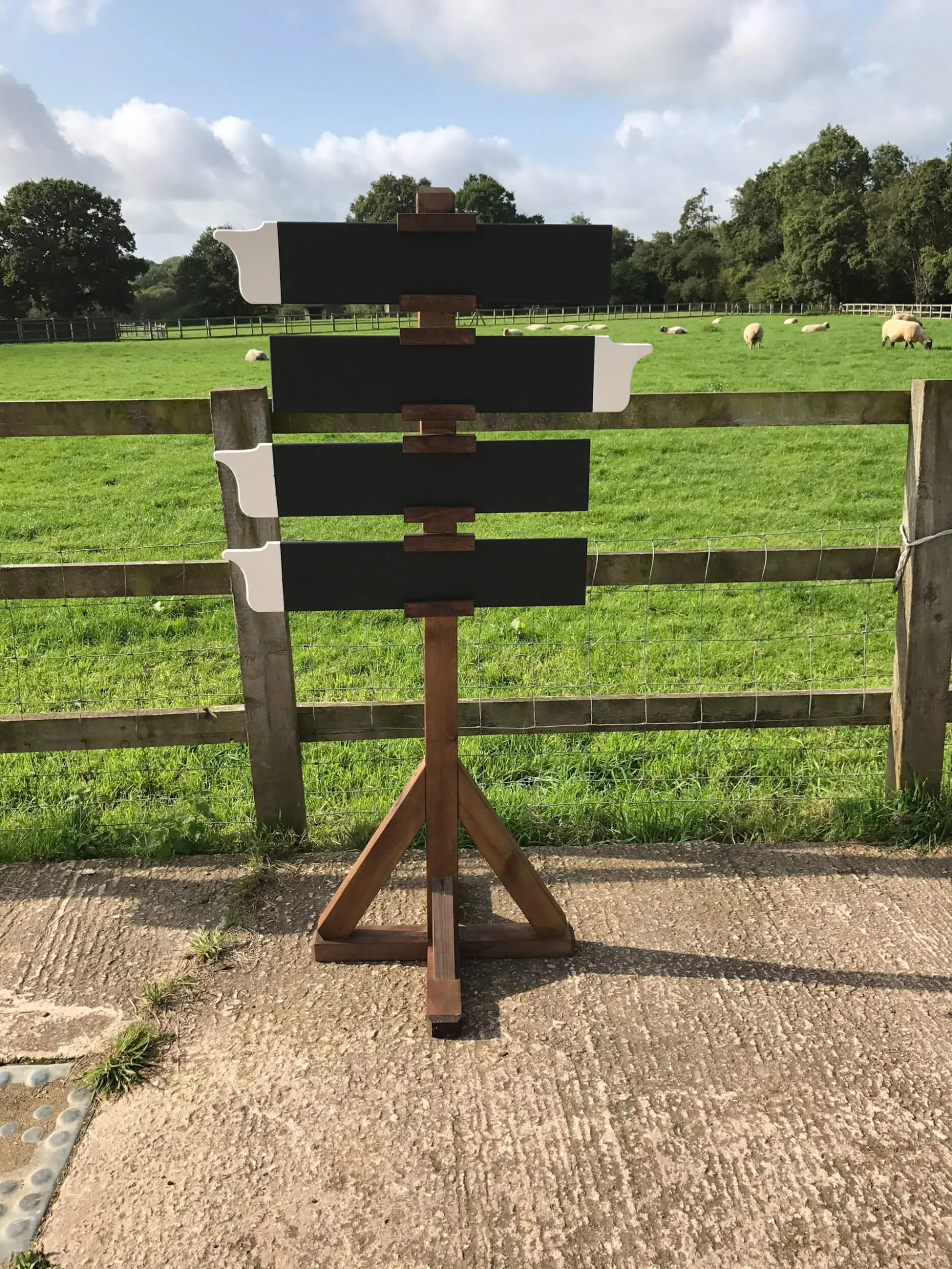 Directional Sign Post - Rustic with four black arrow boards on a wooden tripod base, available to hire for your wedding or event.