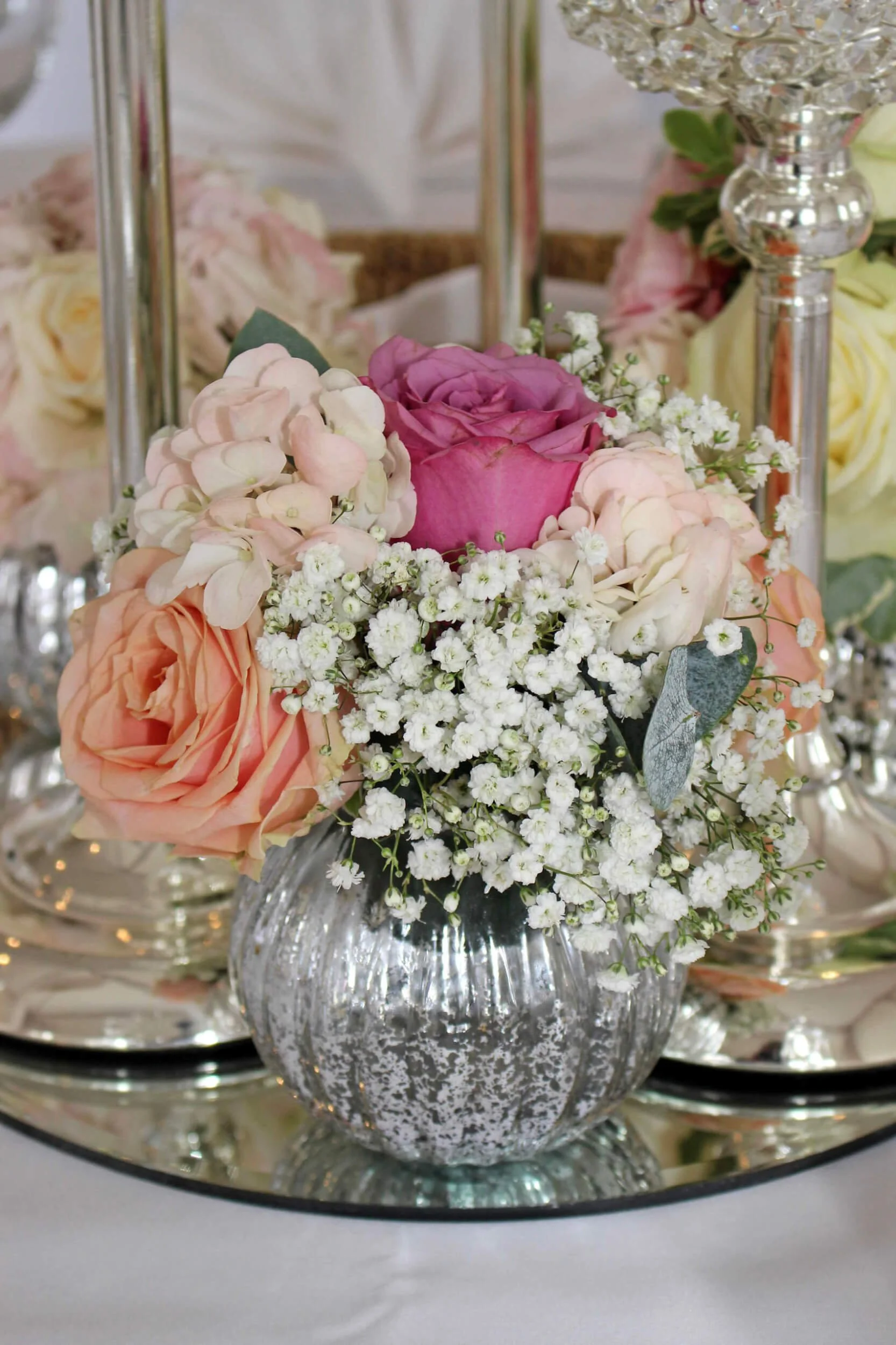 Pumpkin Vase - Silver with pink, peach, and white flowers in a textured silver pumpkin-shaped vase, available to hire for your wedding or event.