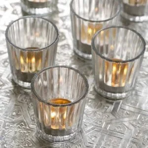 Mini Fluted Clear Glass Tealight holders with lit candles, available to hire for your wedding or event.