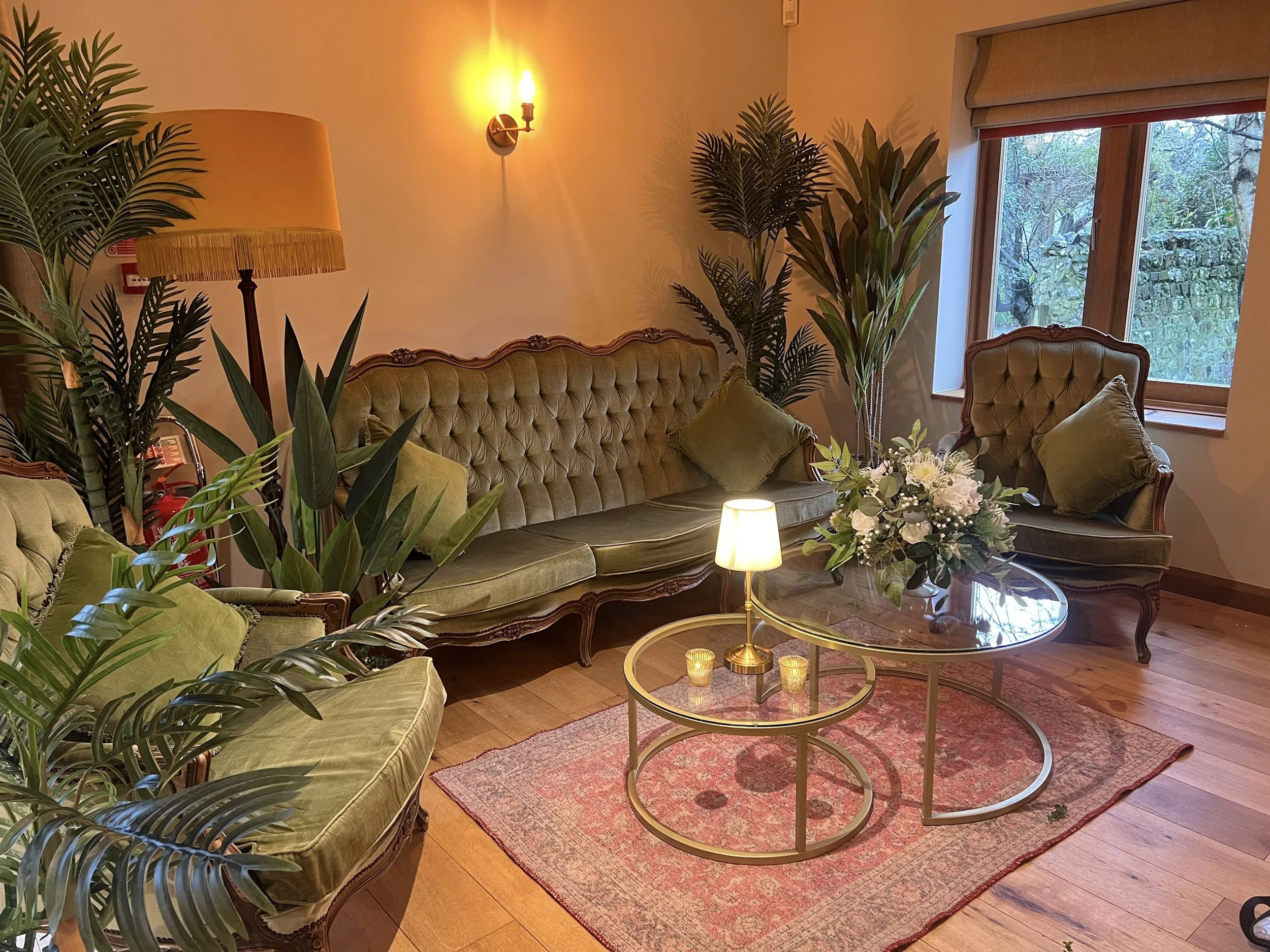 Heritage Collection - Verdant (Antique Green) - Design Lounge Furniture Setup featuring antique green velvet sofa and armchair with plants and lamps, available to hire for your wedding or event.