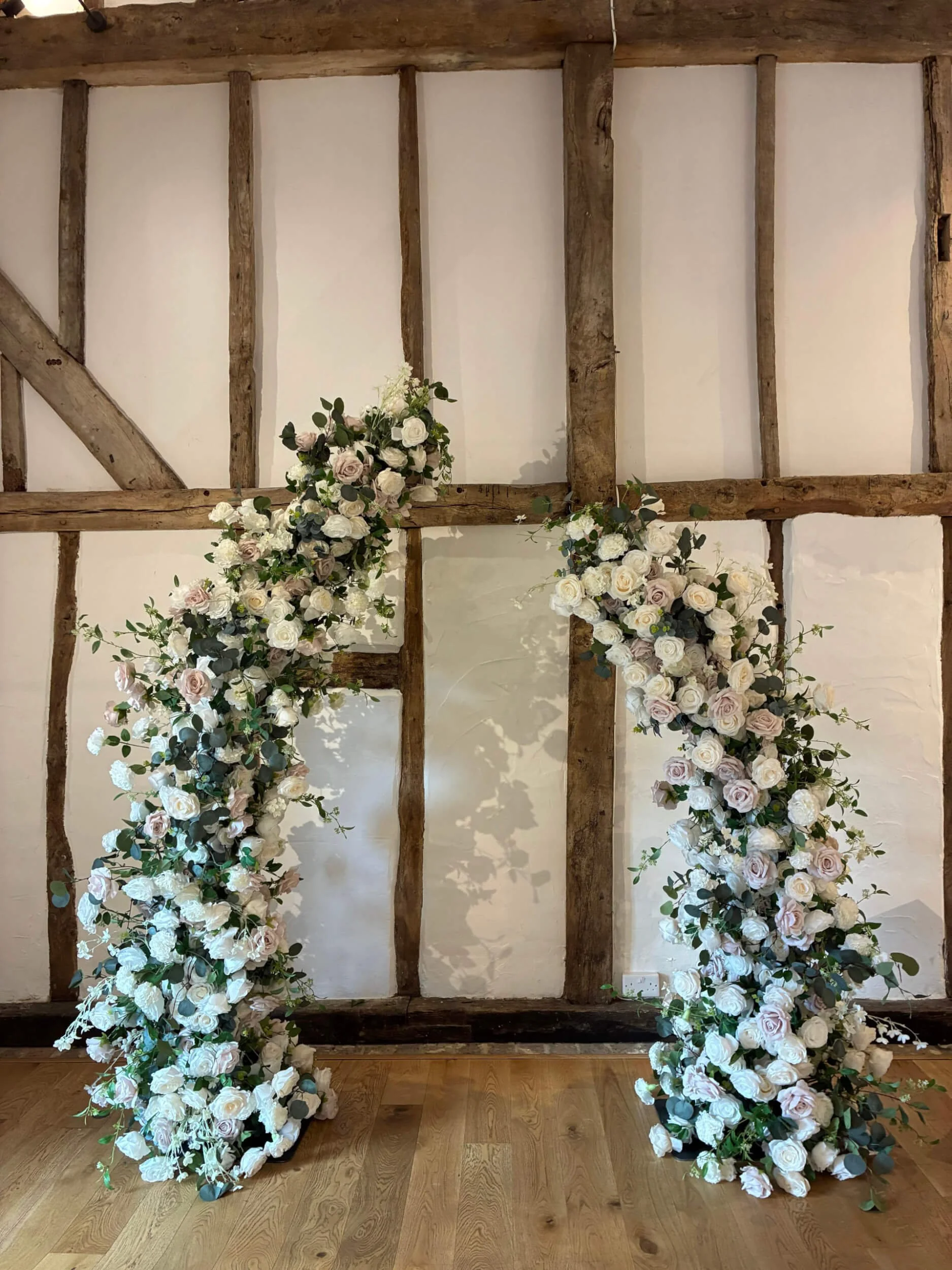 Faux Florals - Bespoke Asymetric/Broken Arch with white and pale pink roses and greenery, available to hire for your wedding or event.