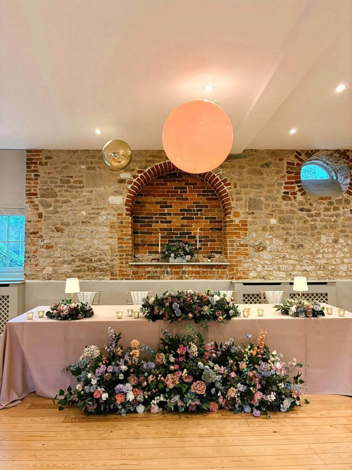 Faux Flower Decoration for tables Prices To styled as Faux Flower Decoration for tables featuring pastel floral arrangements and candles, available to hire for your wedding or event.