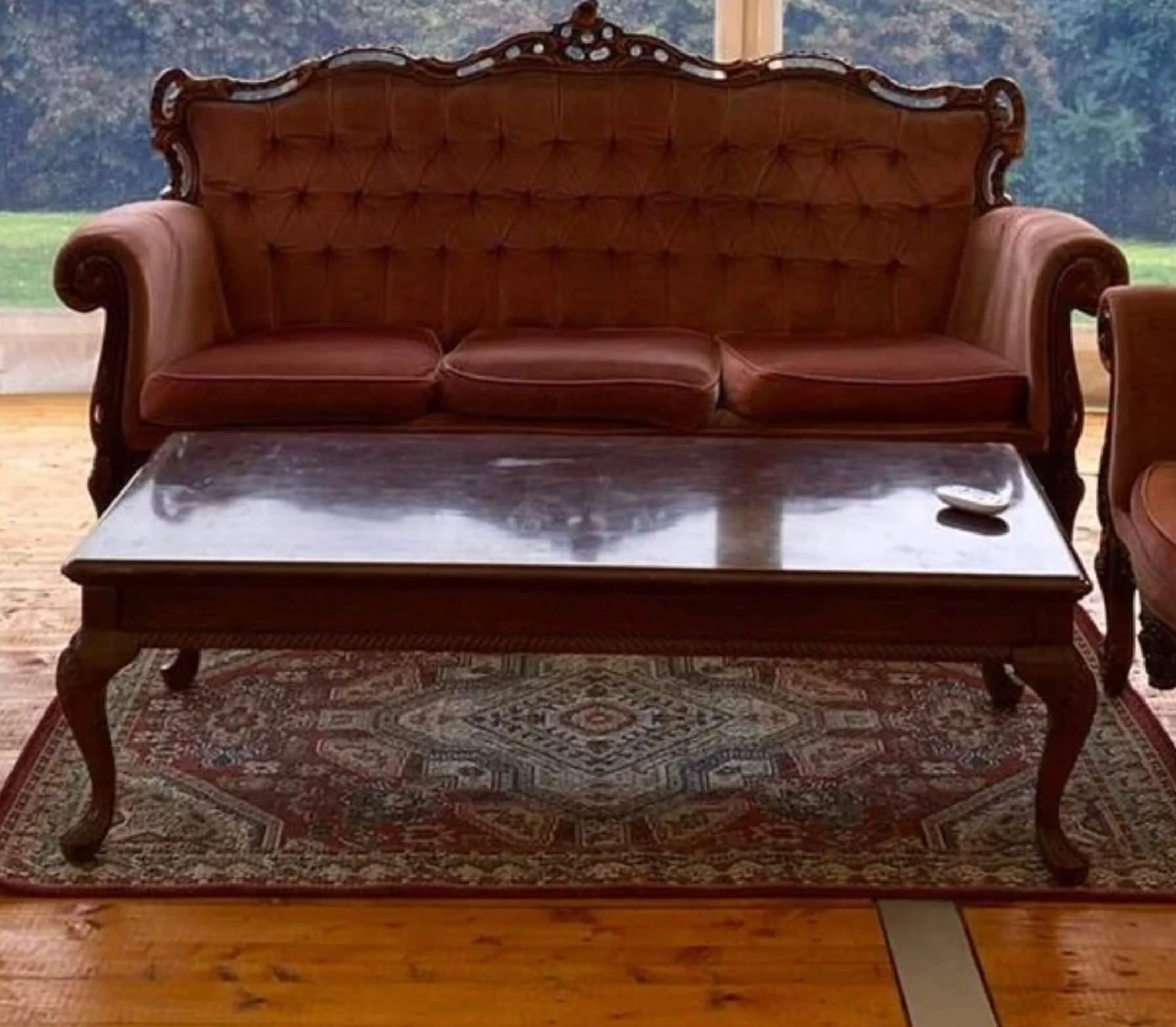 Antique Coffee Table with dark wood and curved legs on a patterned rug, available to hire for your wedding or event.