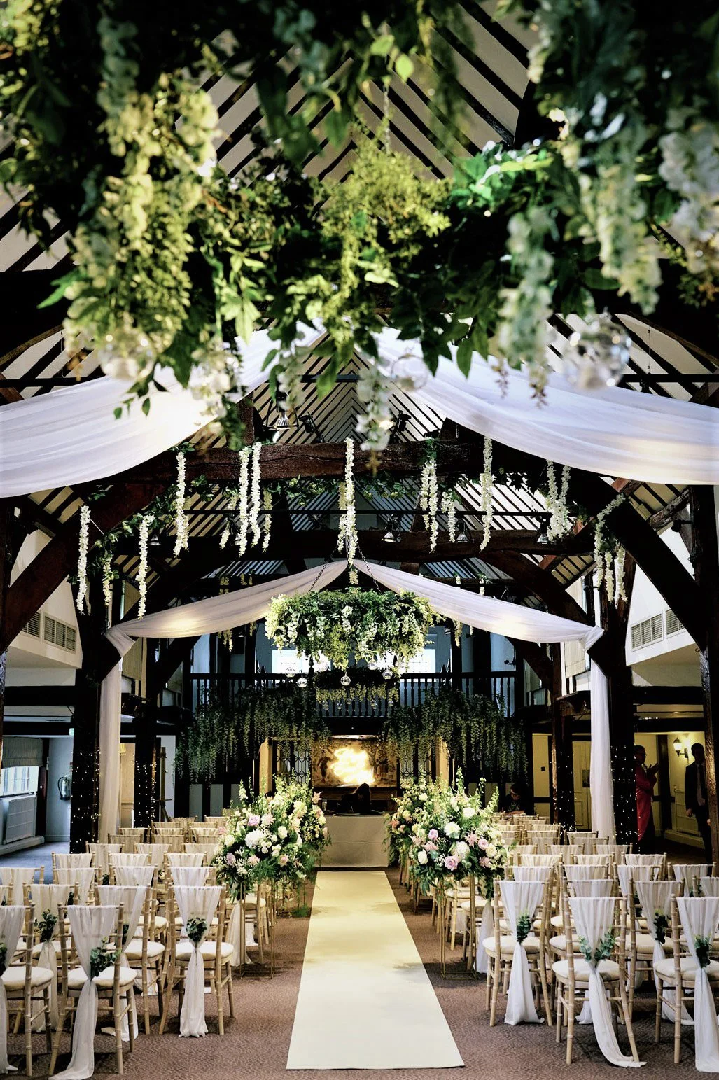 Bespoke Ceiling Install Prices To featuring white draped fabric and hanging greenery, available to hire for your wedding or event.