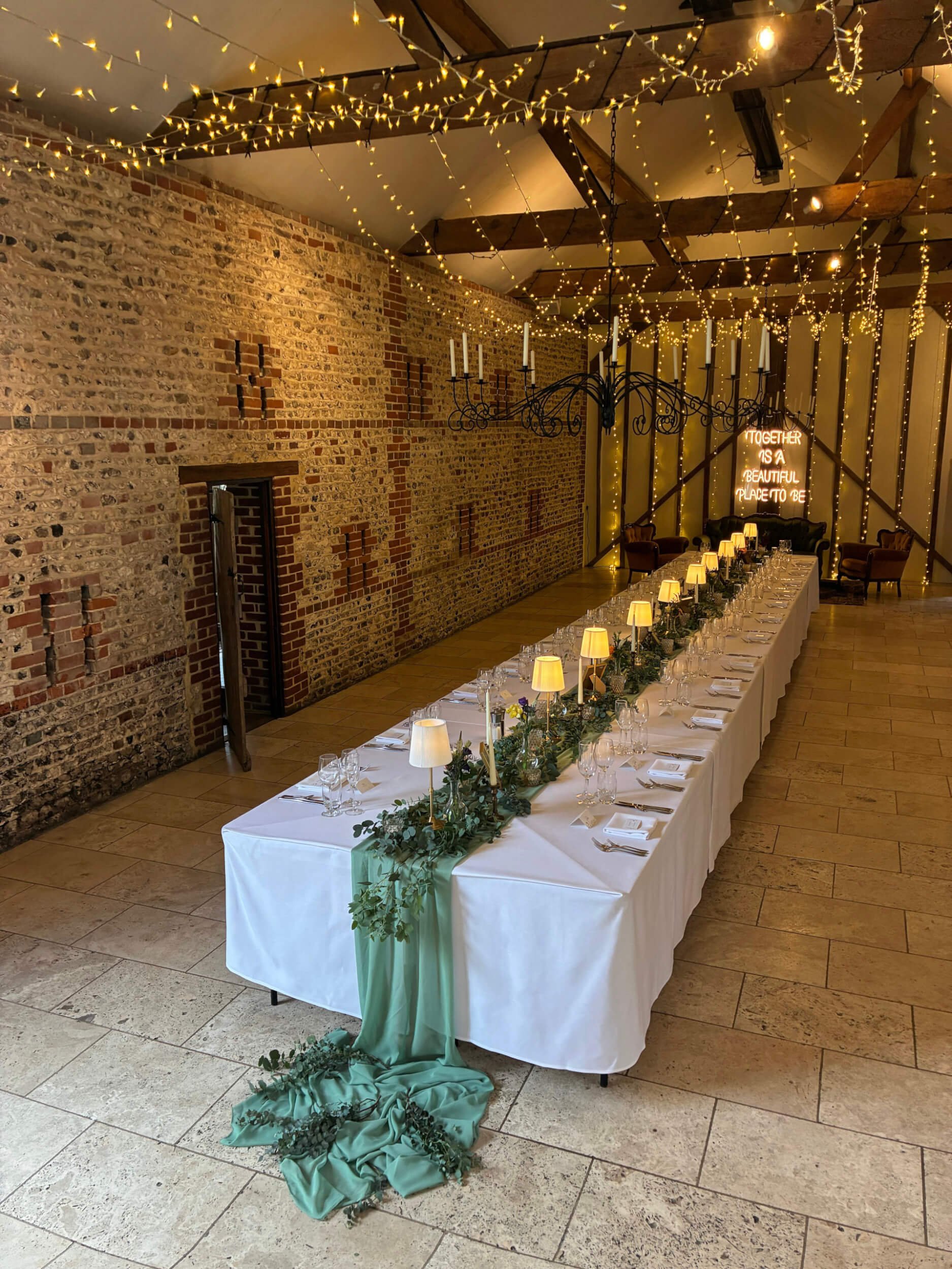 Fairy Light Ceiling Installation Prices To show warm fairy lights strung across wooden beams above a decorated banquet table, available to hire for your wedding or event.