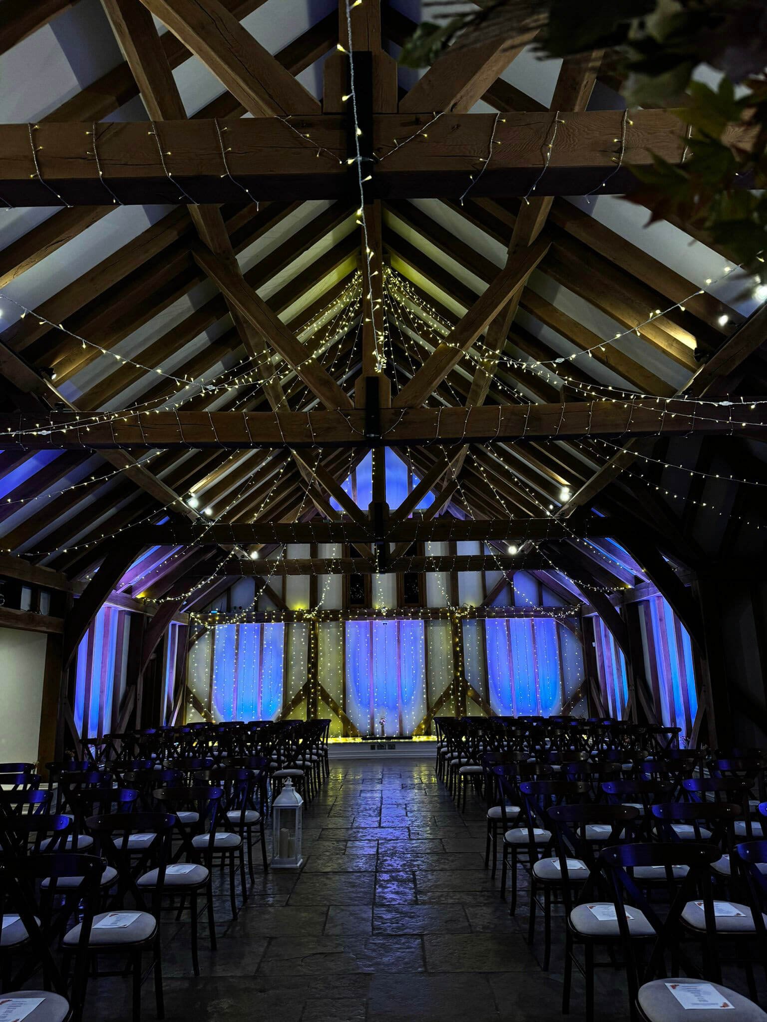 Fairy Light Ceiling Installation Prices From showing warm white fairy lights strung across wooden beams in a rustic venue, available to hire for your wedding or event.