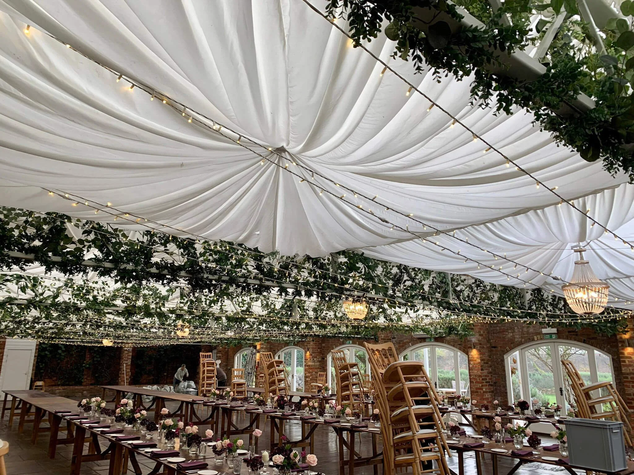 Faux Foliage Ceiling Decoration Bespoke Prices To with white draped ceiling, string lights, and greenery, available to hire for your wedding or event.