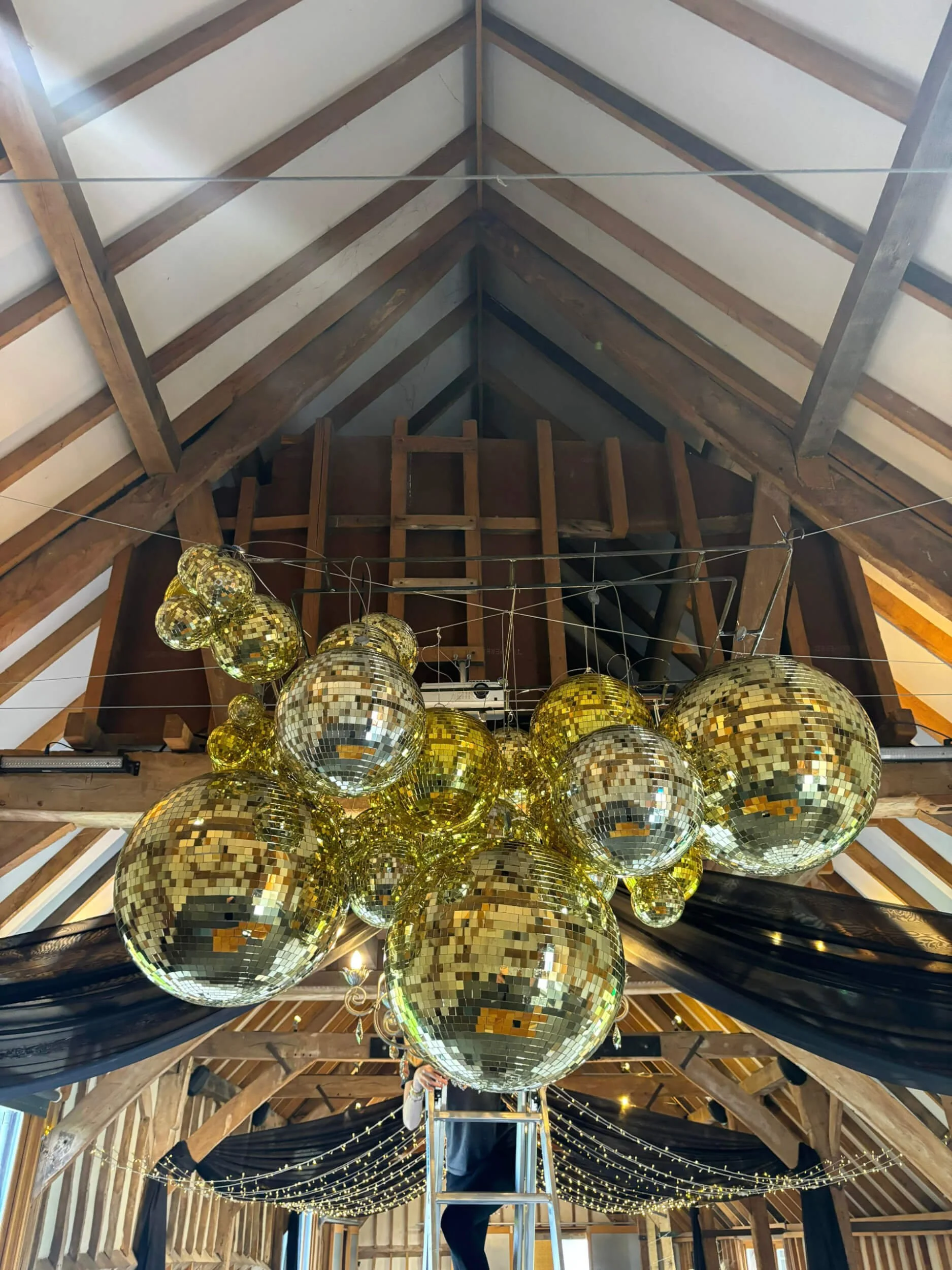 Mirror Ball/Disco Ball - Gold - 4/6 inch (hanging) clustered in various sizes, suspended from ceiling beams, available to hire for your wedding or event.
