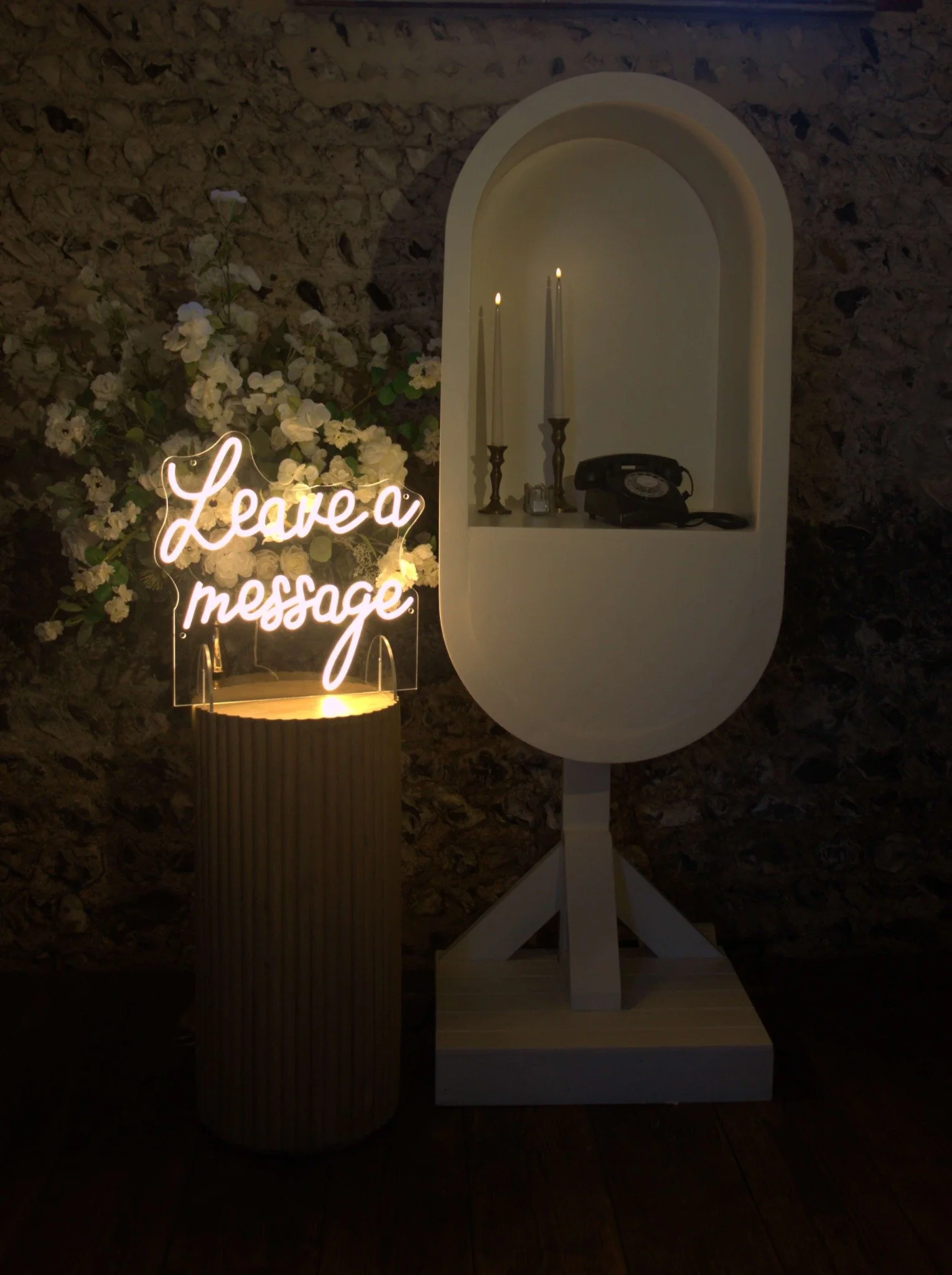 Freestanding Leave a Message neon sign beside a wedding audio guest book
