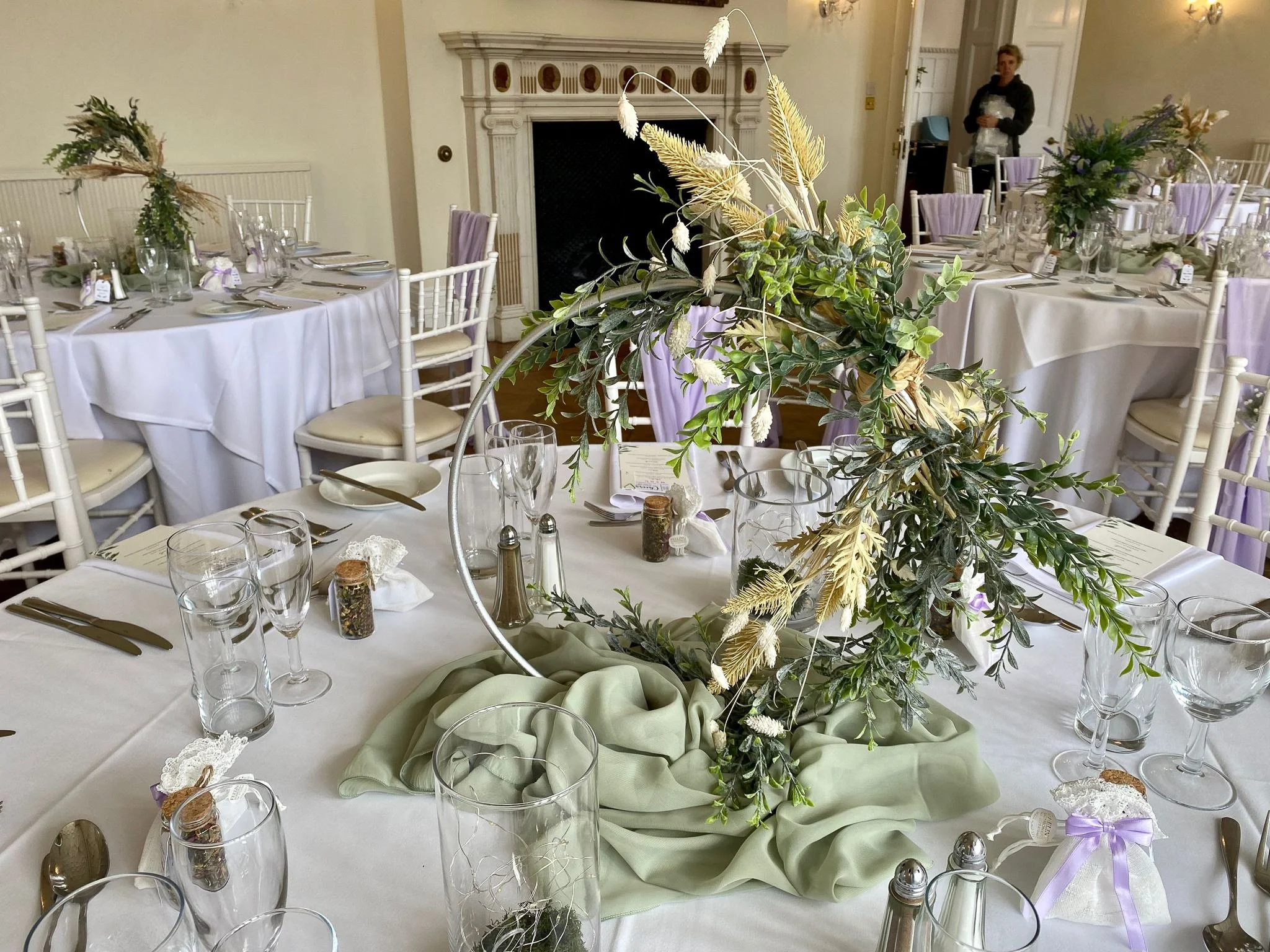 Wedding hoop centrepiece styled with florals and greenery on a reception table