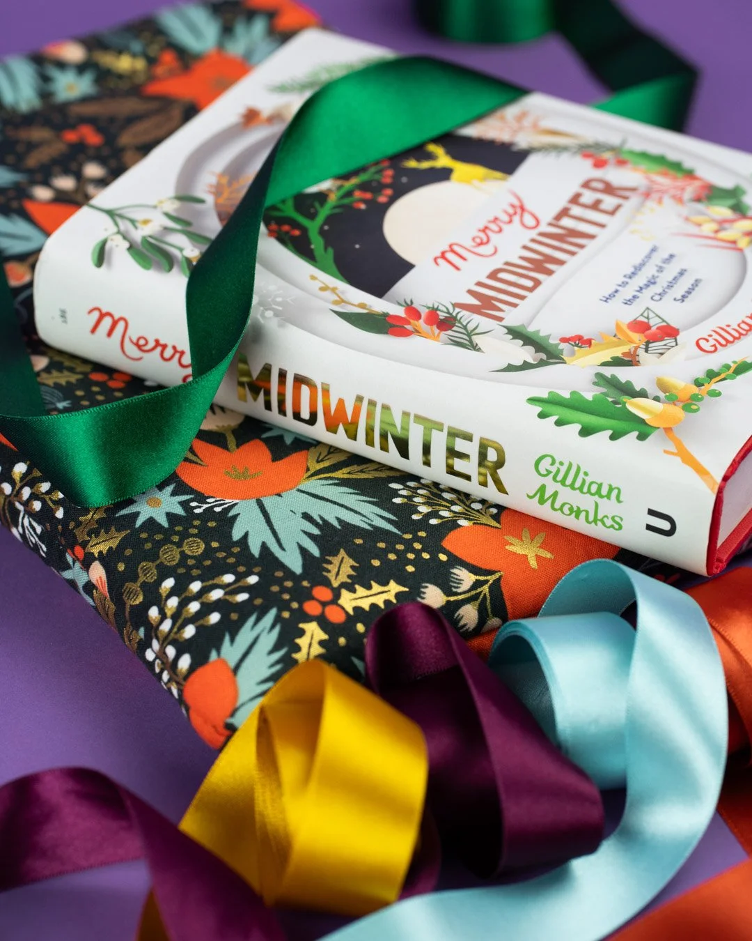 A Christmas book sleeve with Merry Midwinter book on top