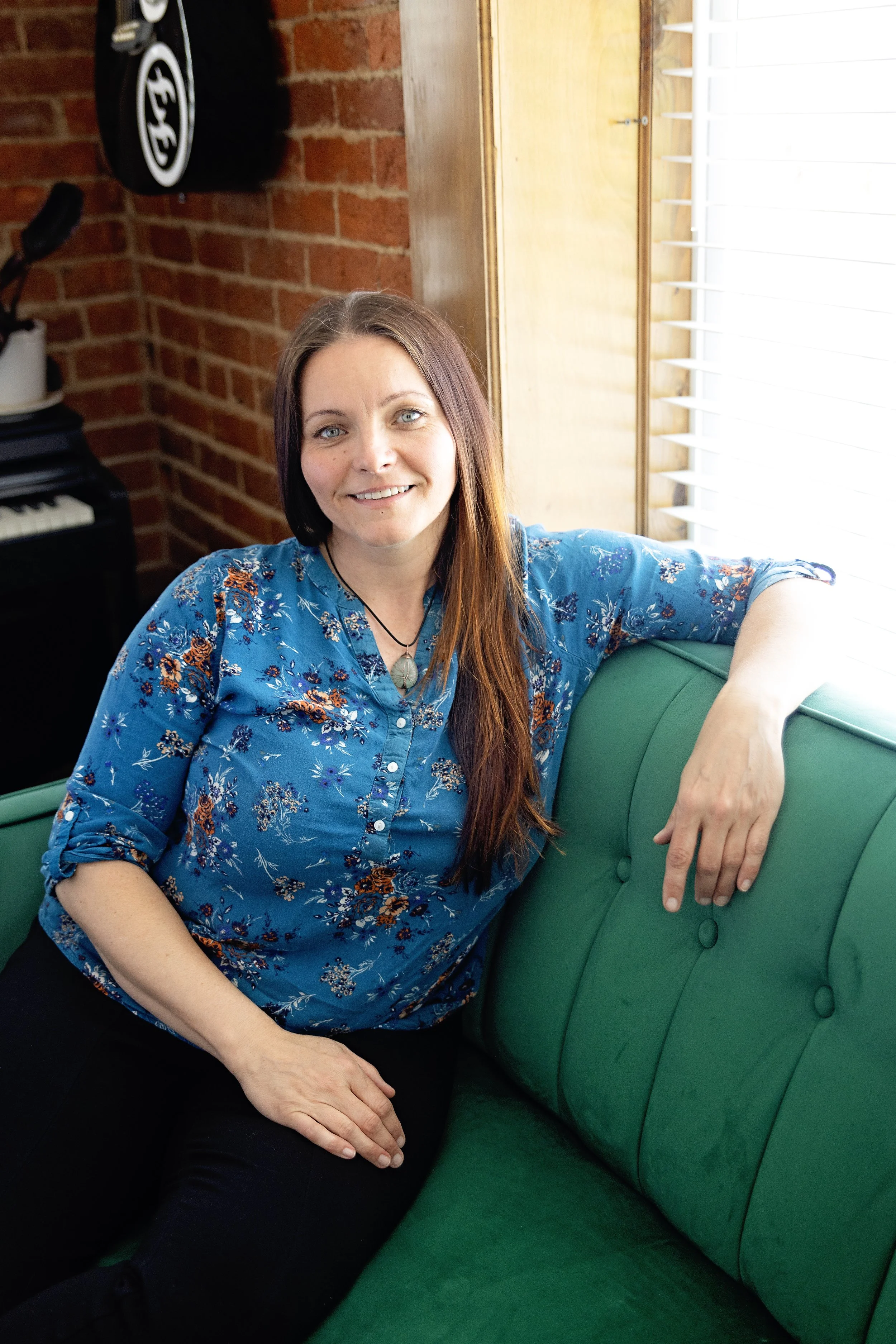 Picture of Amanda Snow LMT sitting on green couch.